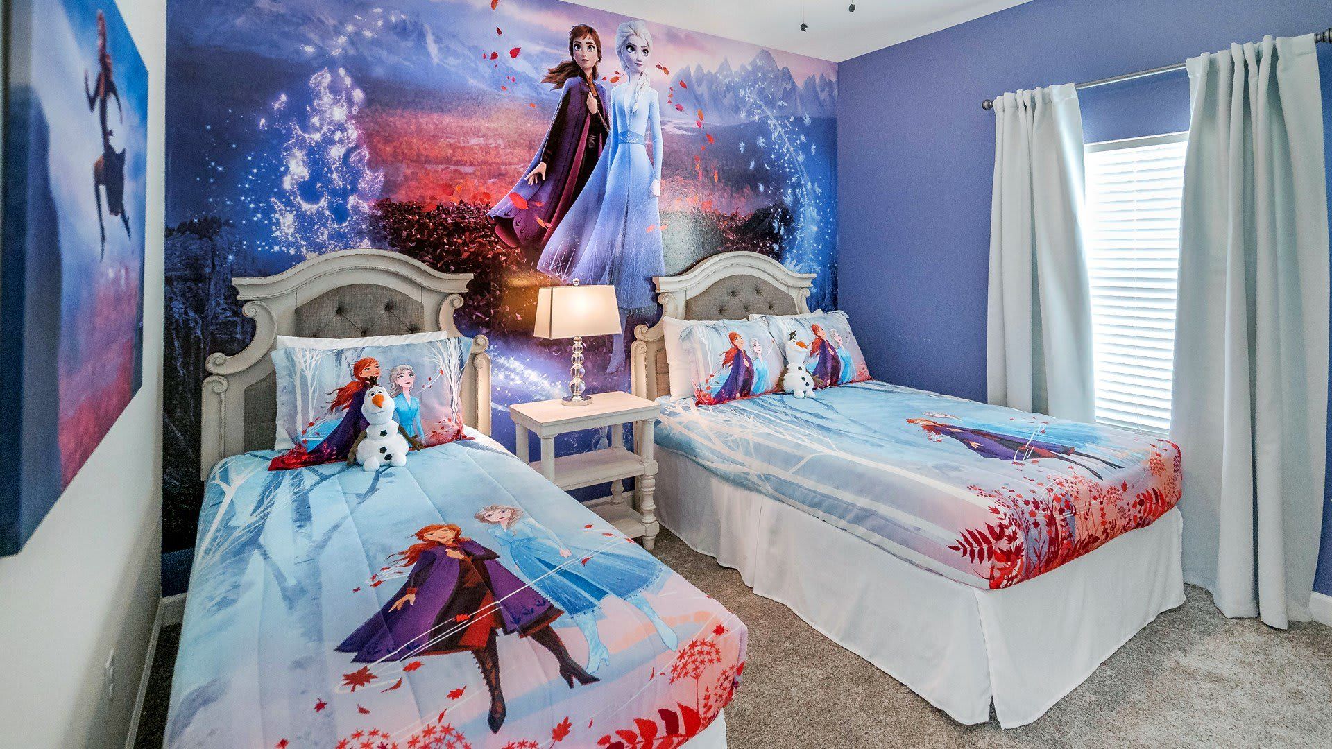 Whimsical Frozen-themed room featuring both twin and full beds for enchanting and cozy nights