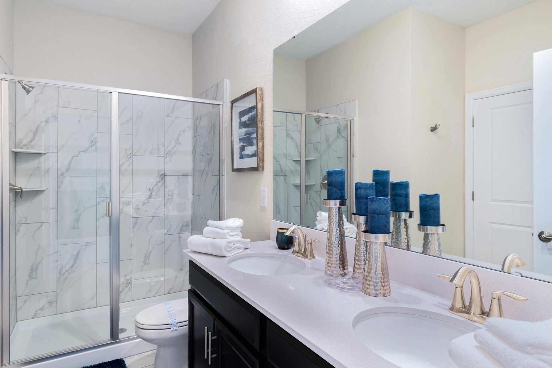 Elegant bathroom w/ dual sinks, marble shower & modern touches!