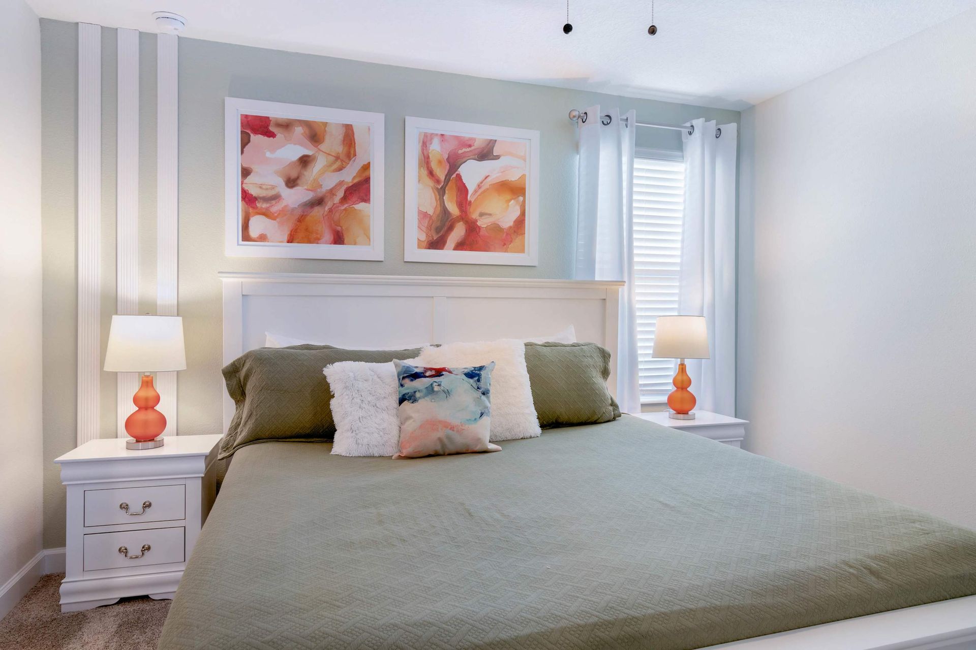 Cozy bedroom w/ vibrant art, warm lighting & a comfy king bed!