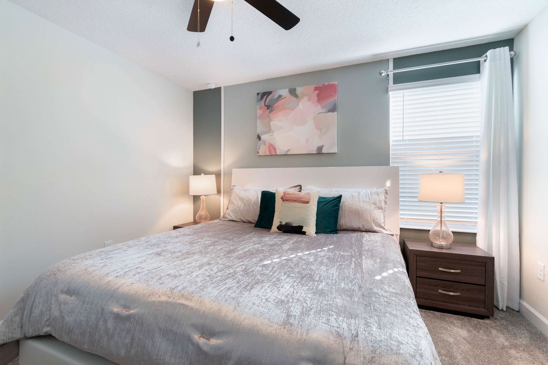 Modern bedroom w/ soft tones, plush bedding & elegant decor!