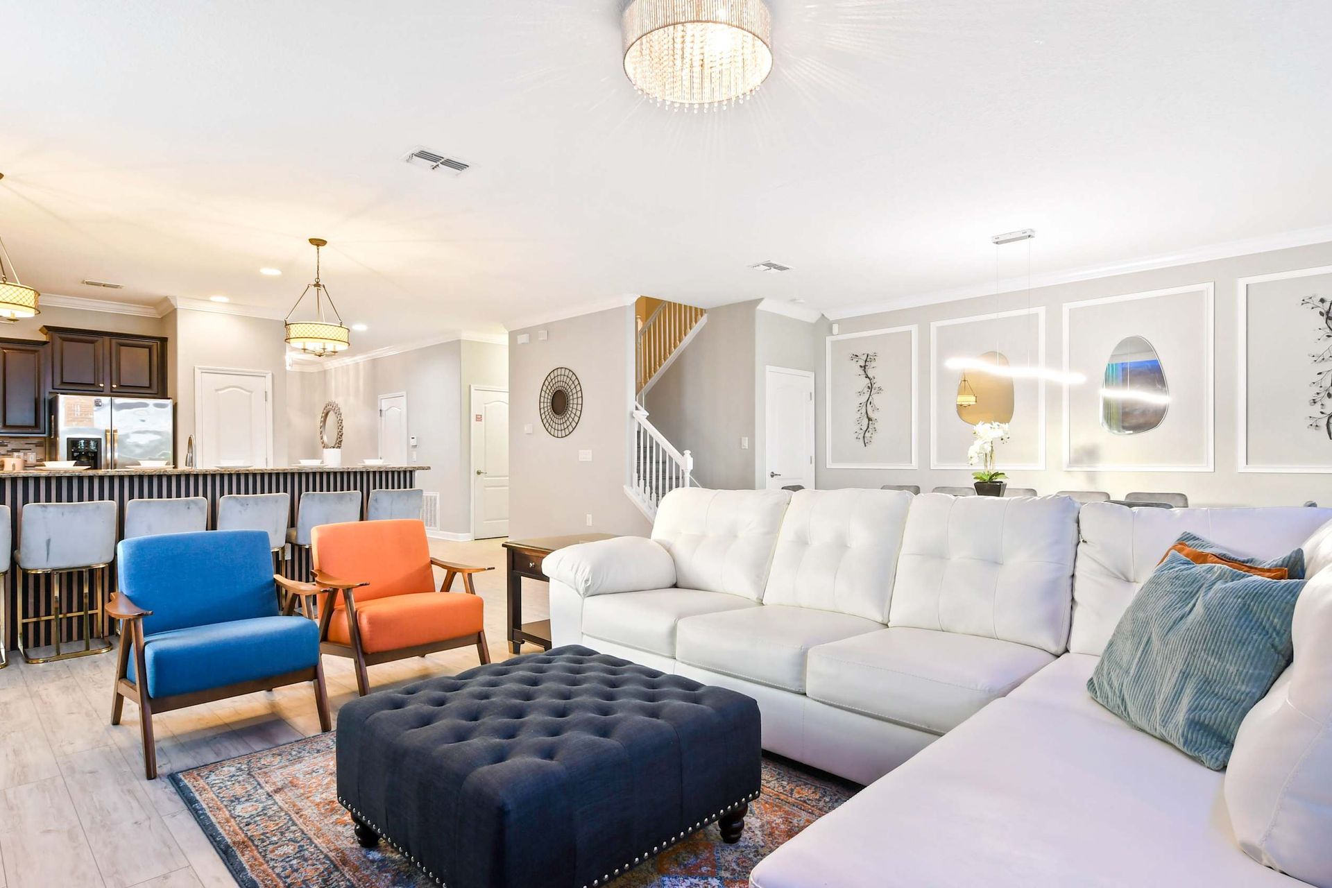 Elegant open-concept living area with stylish seating, modern kitchen, and chic lighting fixtures.