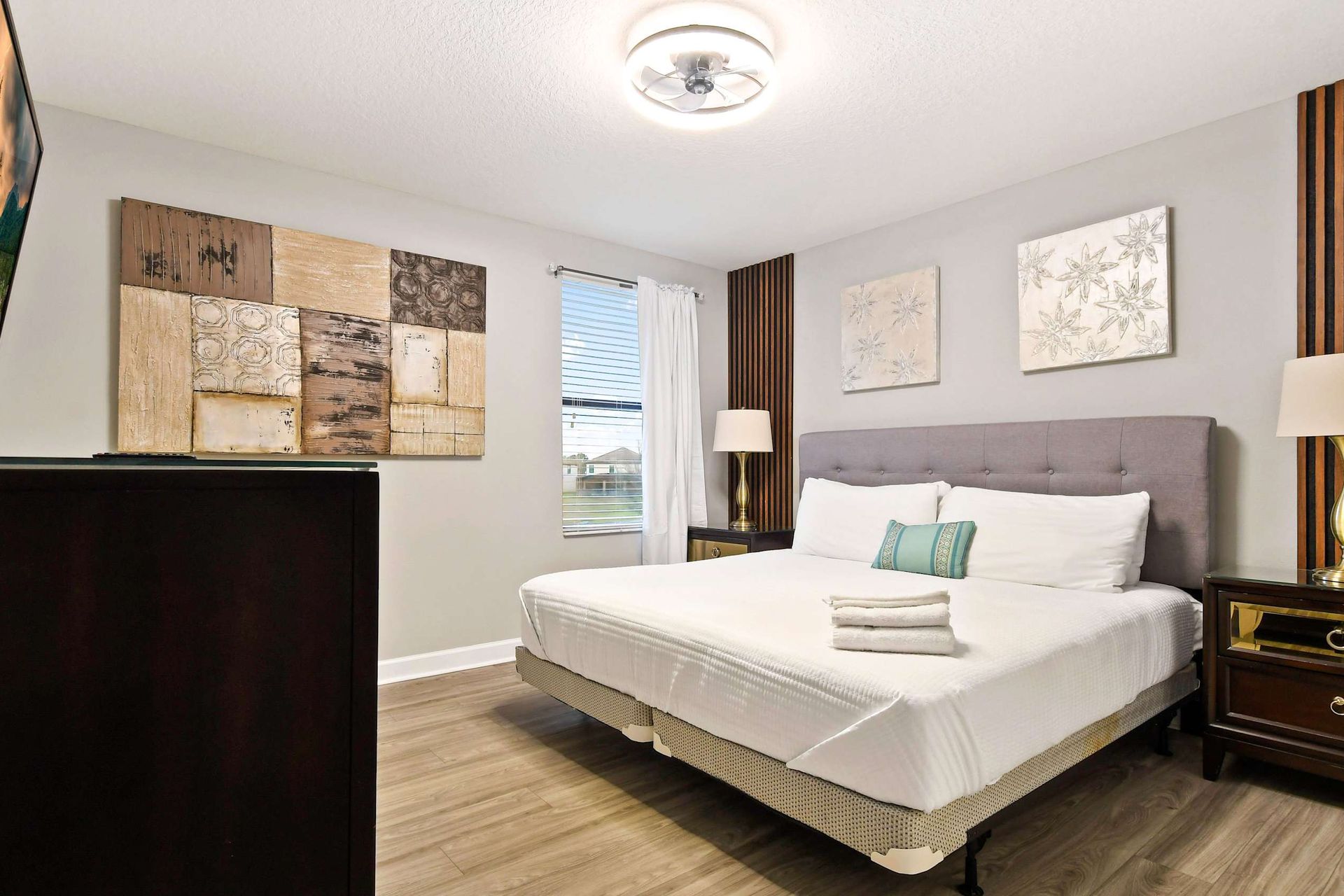 Modern bedroom with gray accents, abstract wall art, and cozy bedding for a stylish and comfortable retreat.