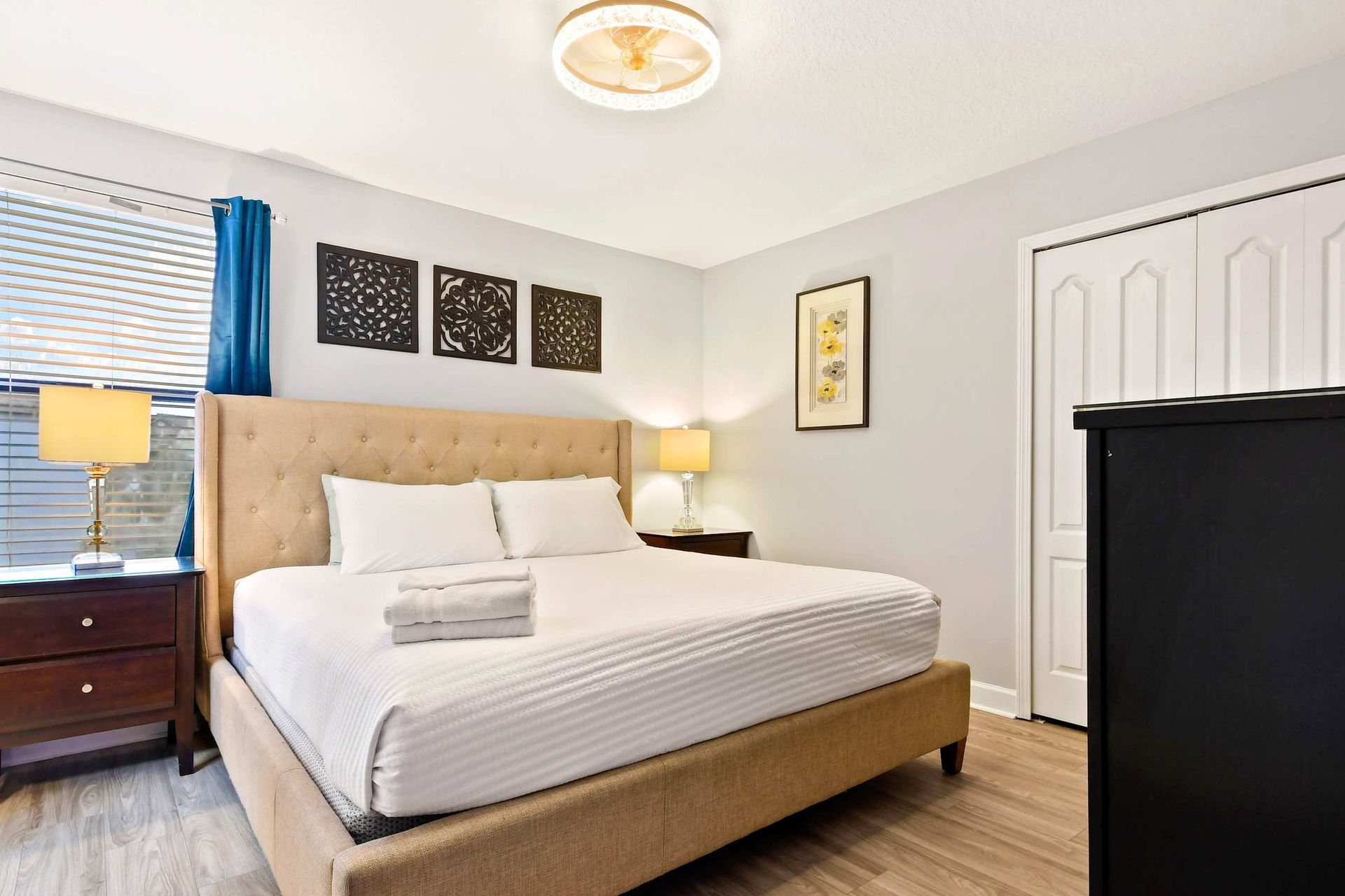 Bright and cozy bedroom with a tufted headboard, modern decor, and soft lighting for a relaxing stay.