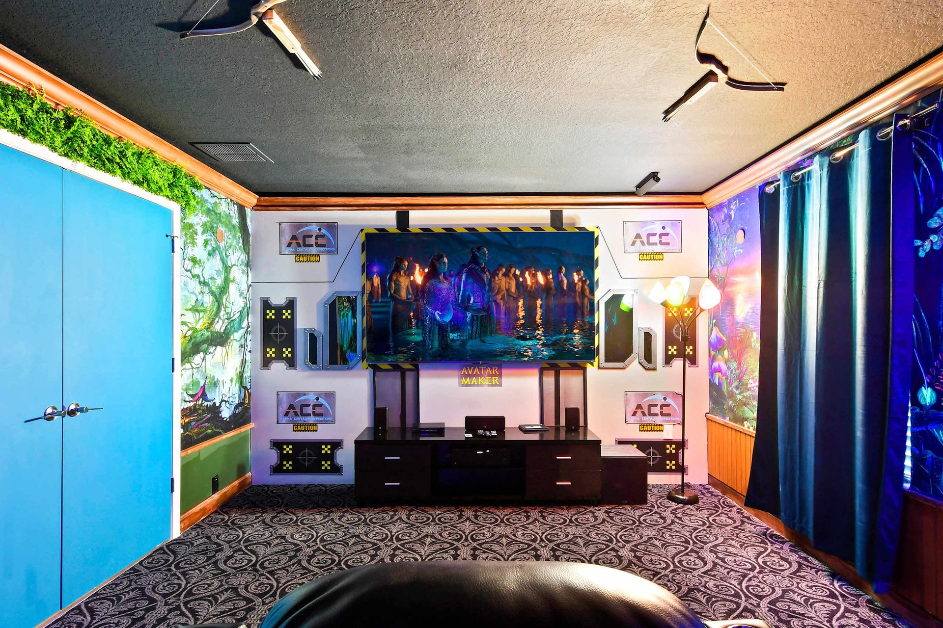 Sci-fi themed theater with a vibrant mural, glowing decor, and a large screen displaying 