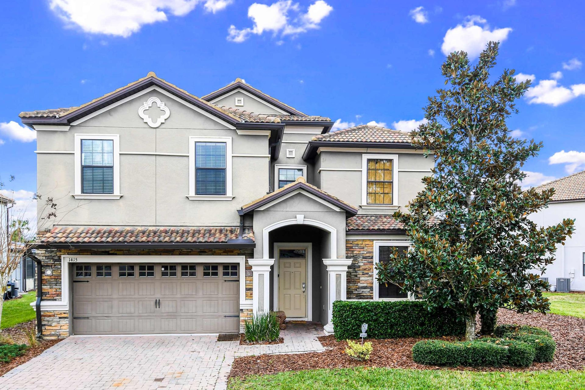 Stunning home, surrounded by lush greenery and featuring a convenient garage for a perfect blend of beauty and functionality