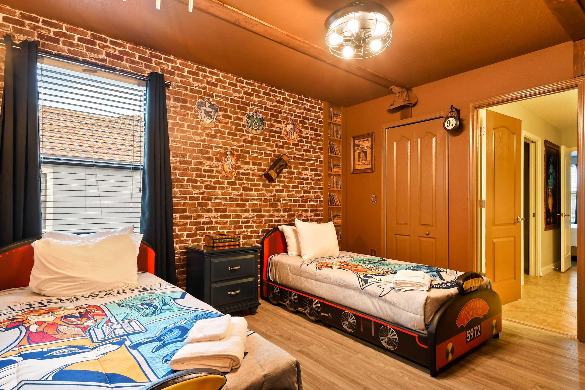 Charming bedroom with brick walls, Hogwarts-themed decor, and cozy twin beds for young wizards.