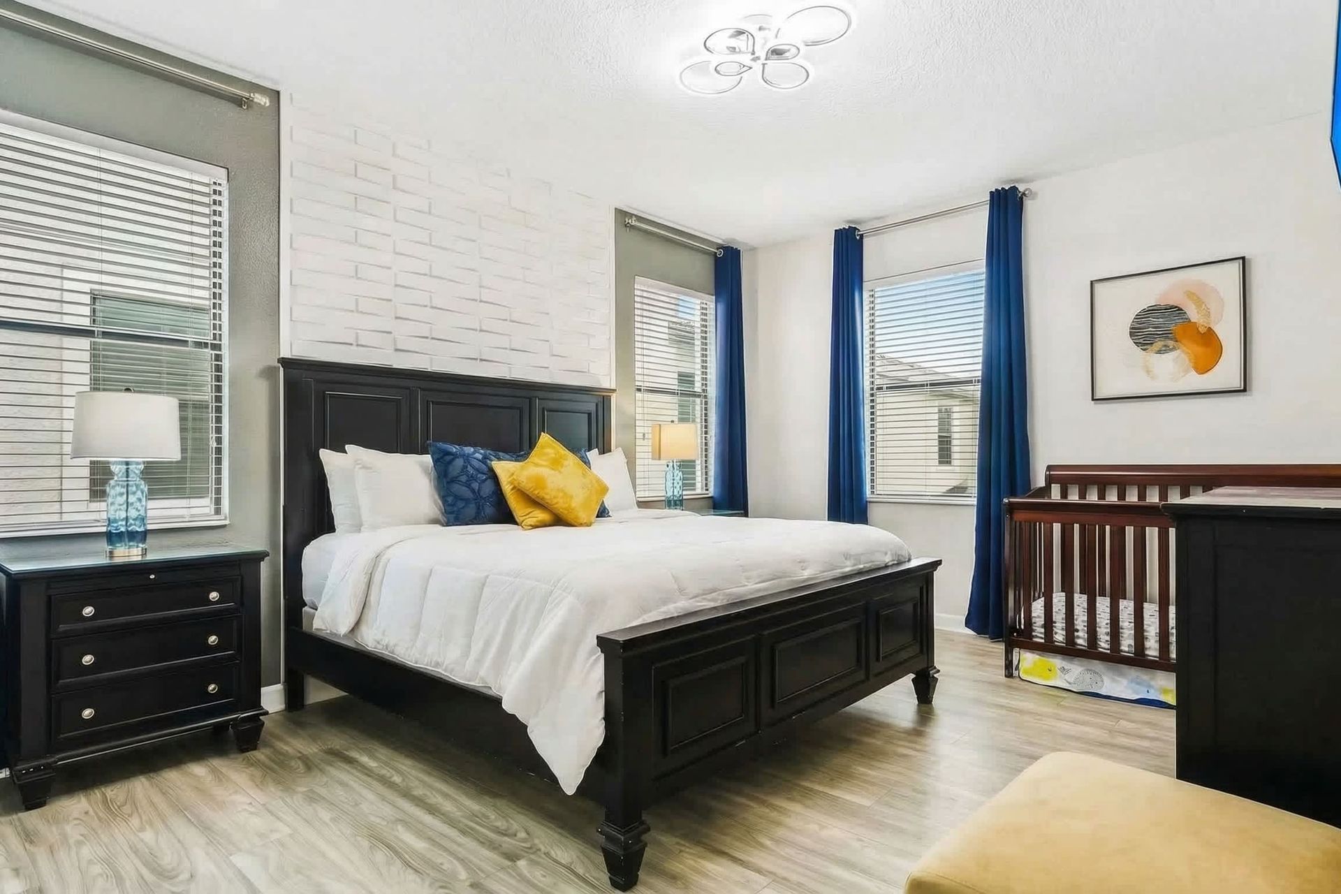 Opulent master bedroom boasts a spacious king bed, complemented by a crib for added comfort