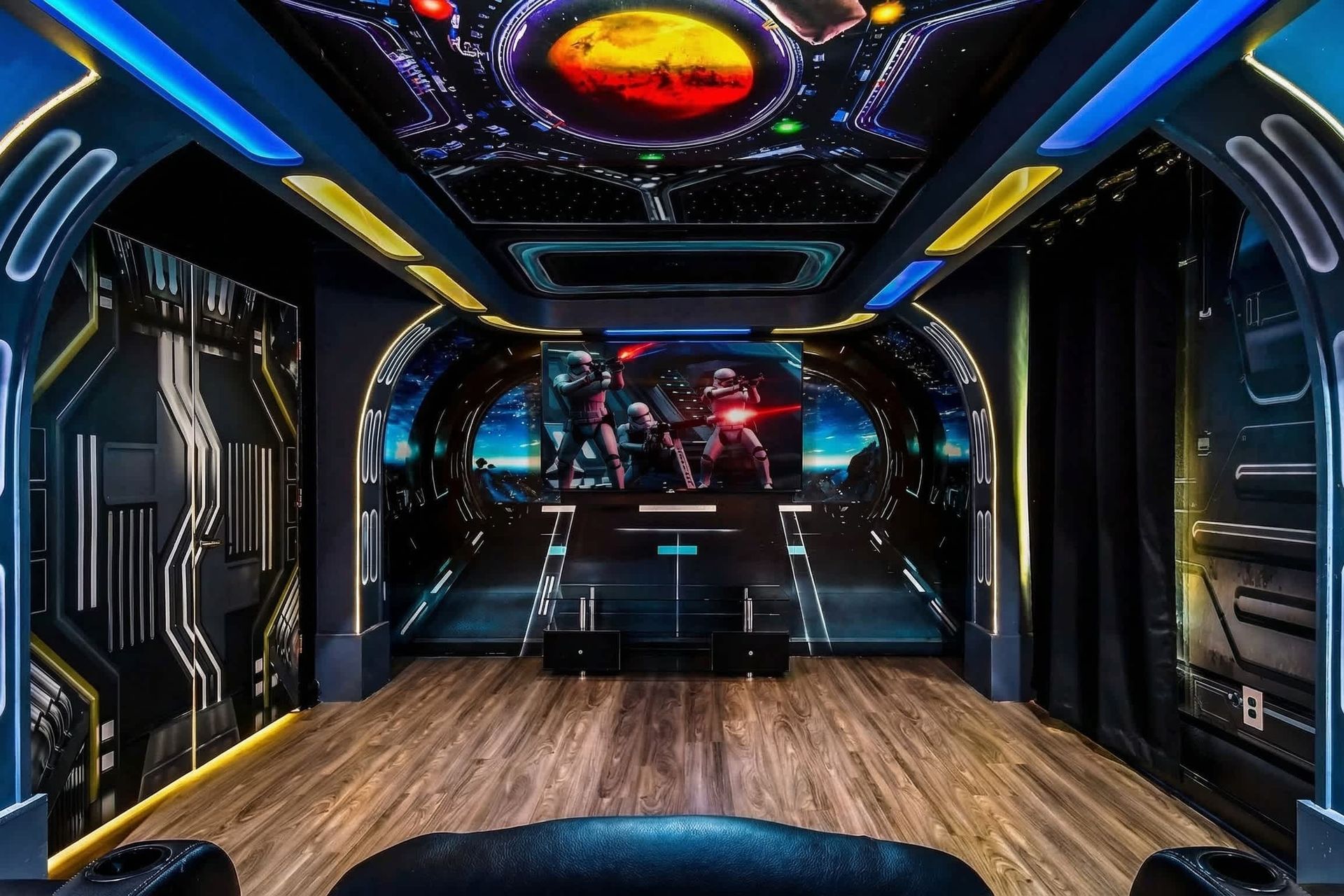 Immersive sci-fi-themed home theater with futuristic decor, cosmic ceiling, and spacious seating.