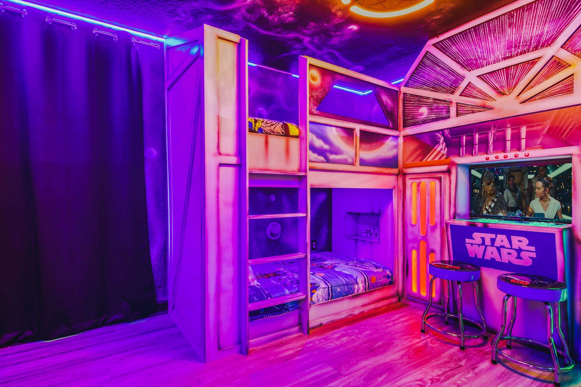 Star Wars-themed bedroom with vibrant neon lighting, custom bunk beds, and a bar area featuring iconic characters.