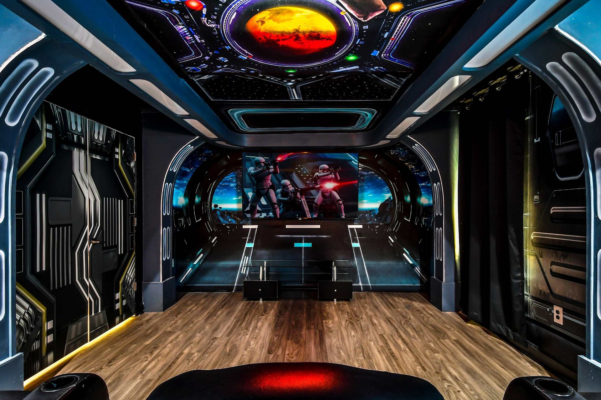 Immersive sci-fi-themed home theater with futuristic decor, cosmic ceiling, and spacious seating.