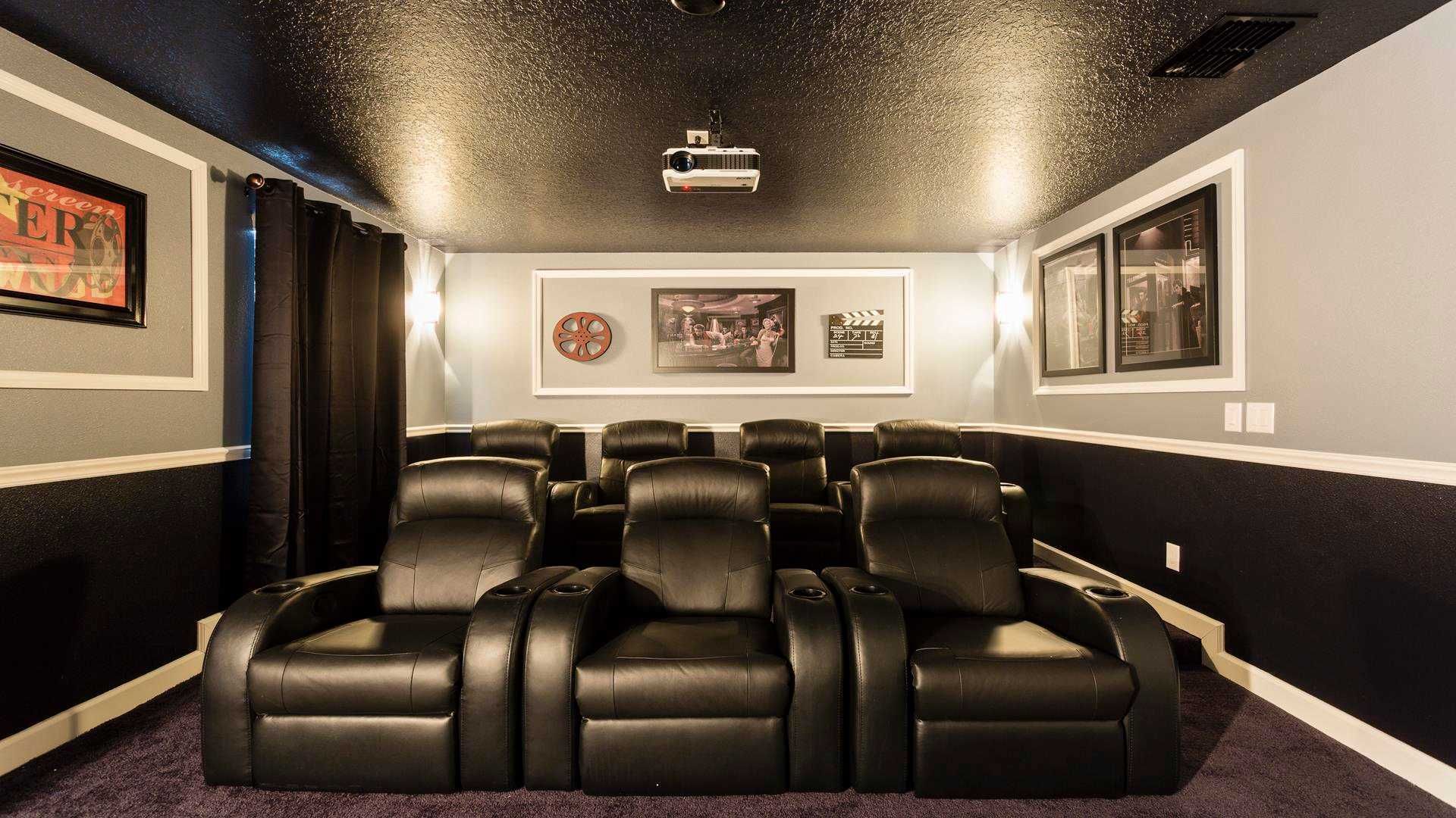 Luxurious home theater featuring plush leather recliners, ambient lighting, and classic cinema decor.