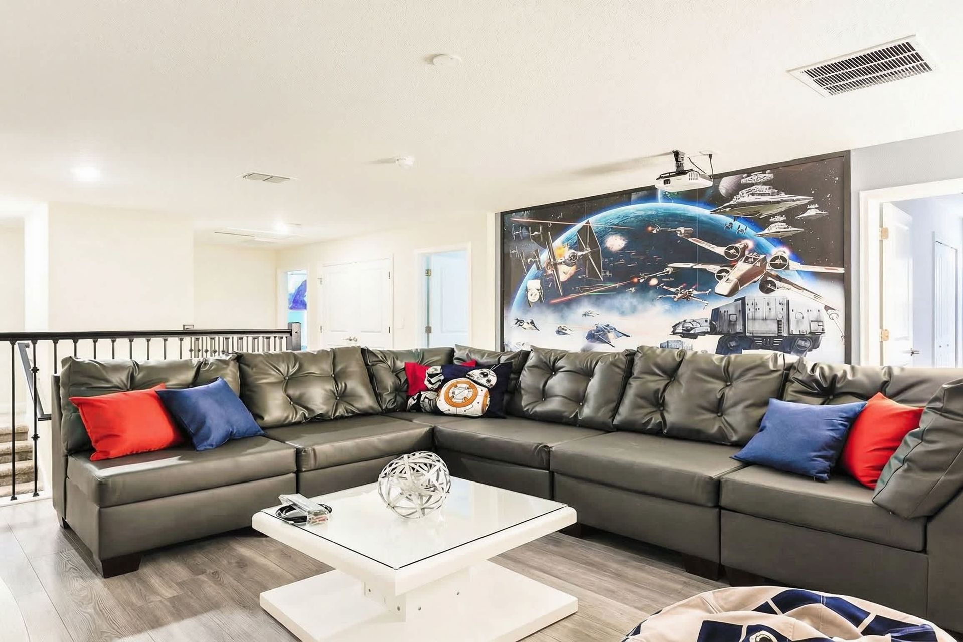 Galactic-themed lounge with cozy sectional, movie projector, and Star Wars decor—perfect for movie nights!