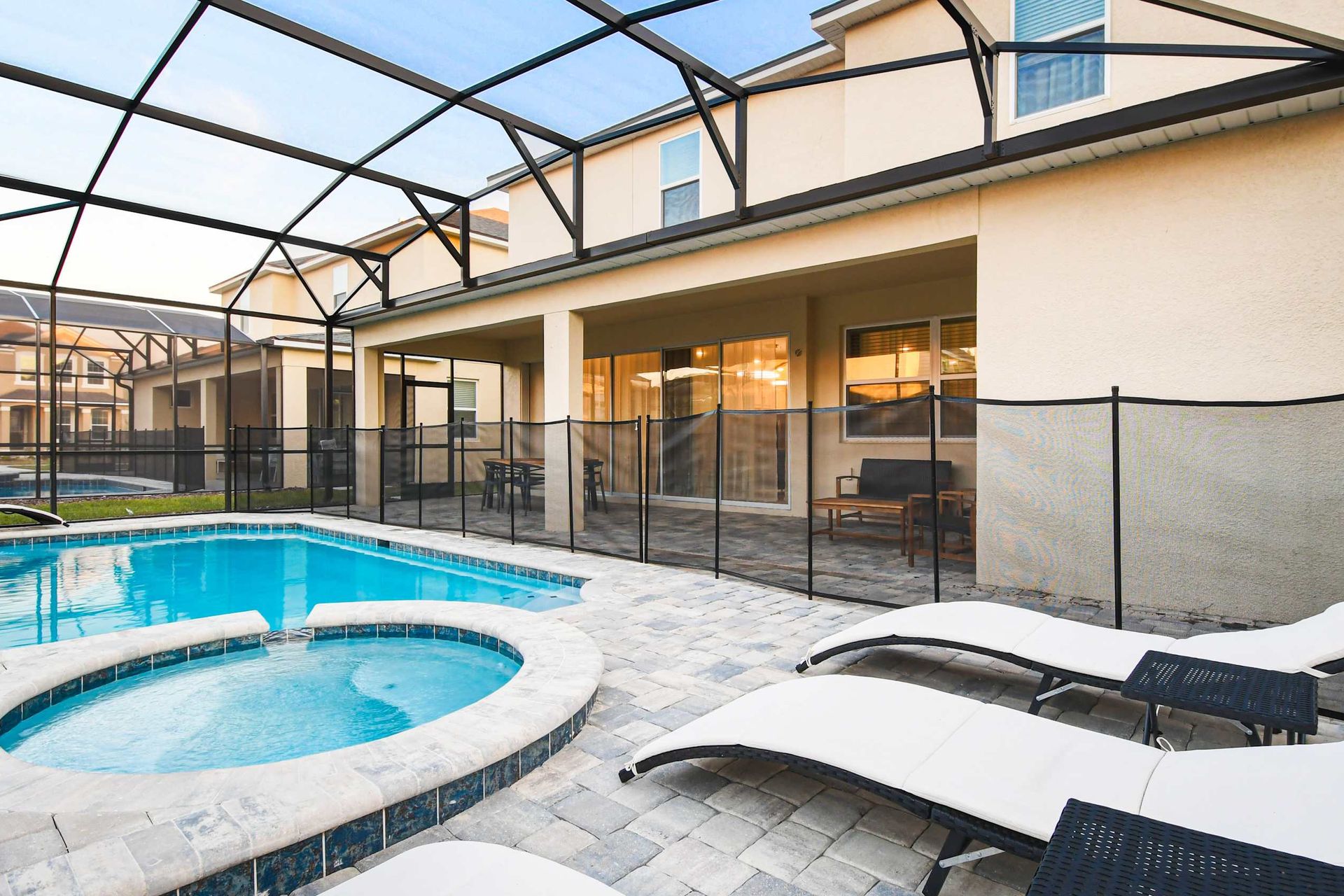Inviting patio with private pool, spa, sun loungers, and covered seating area.
