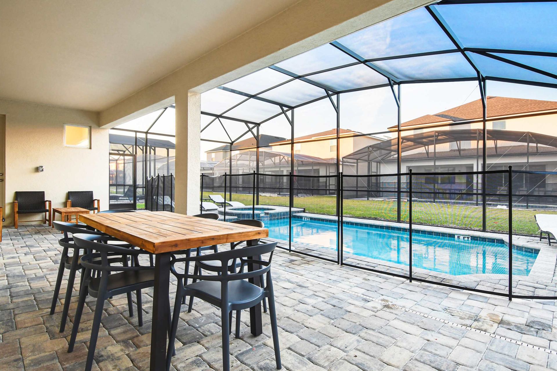 Covered patio with dining area, cozy seating, and a private screened-in pool.