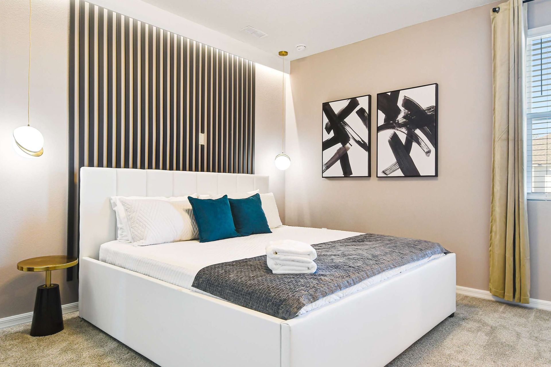 Modern bedroom with bold accent wall, elegant lighting, and cozy bedding.