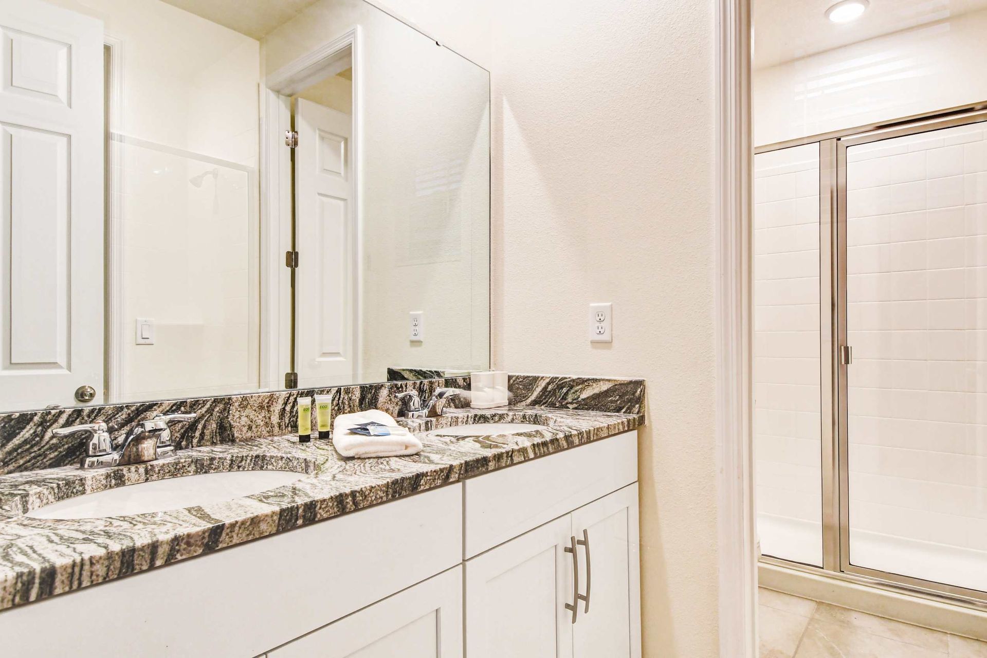 Elegant bathroom with granite countertops, dual sinks, and a spacious shower.