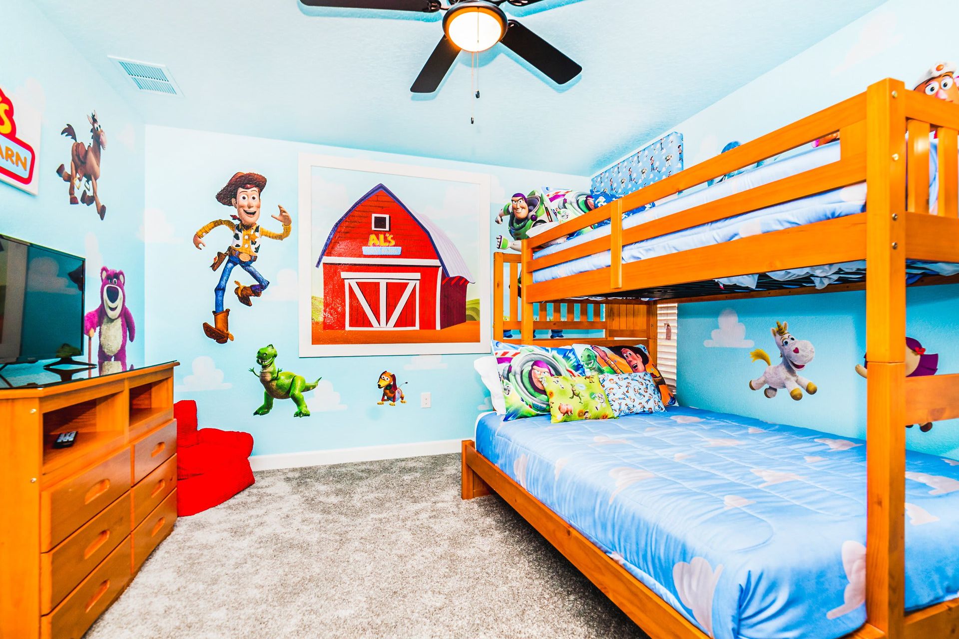 Fun Toy Story-themed bedroom with bunk beds, colorful decor, and a TV.