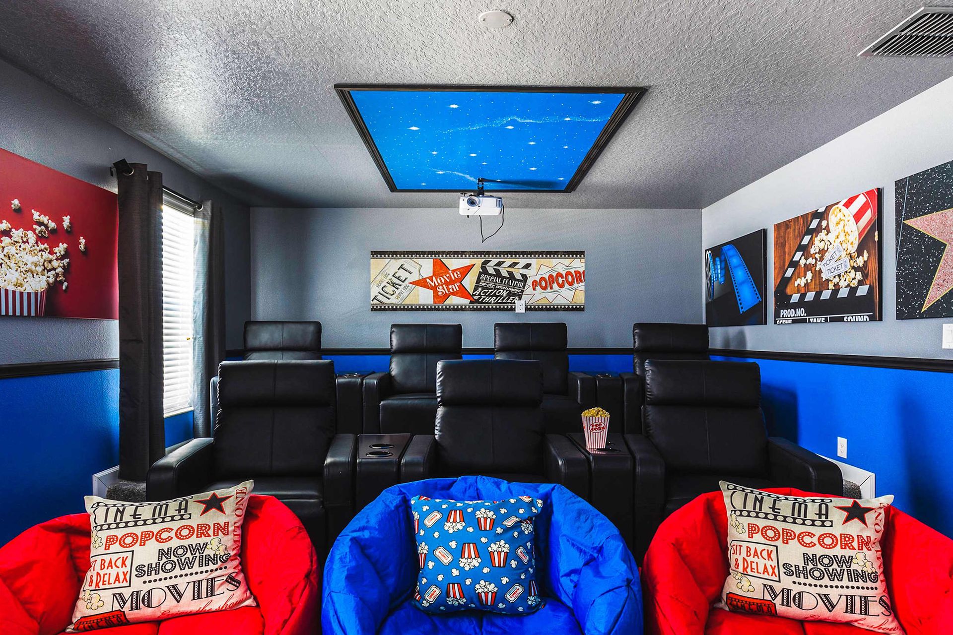 Stylish home theater with reclining seats, bean bags, starry ceiling, and movie-themed decor.