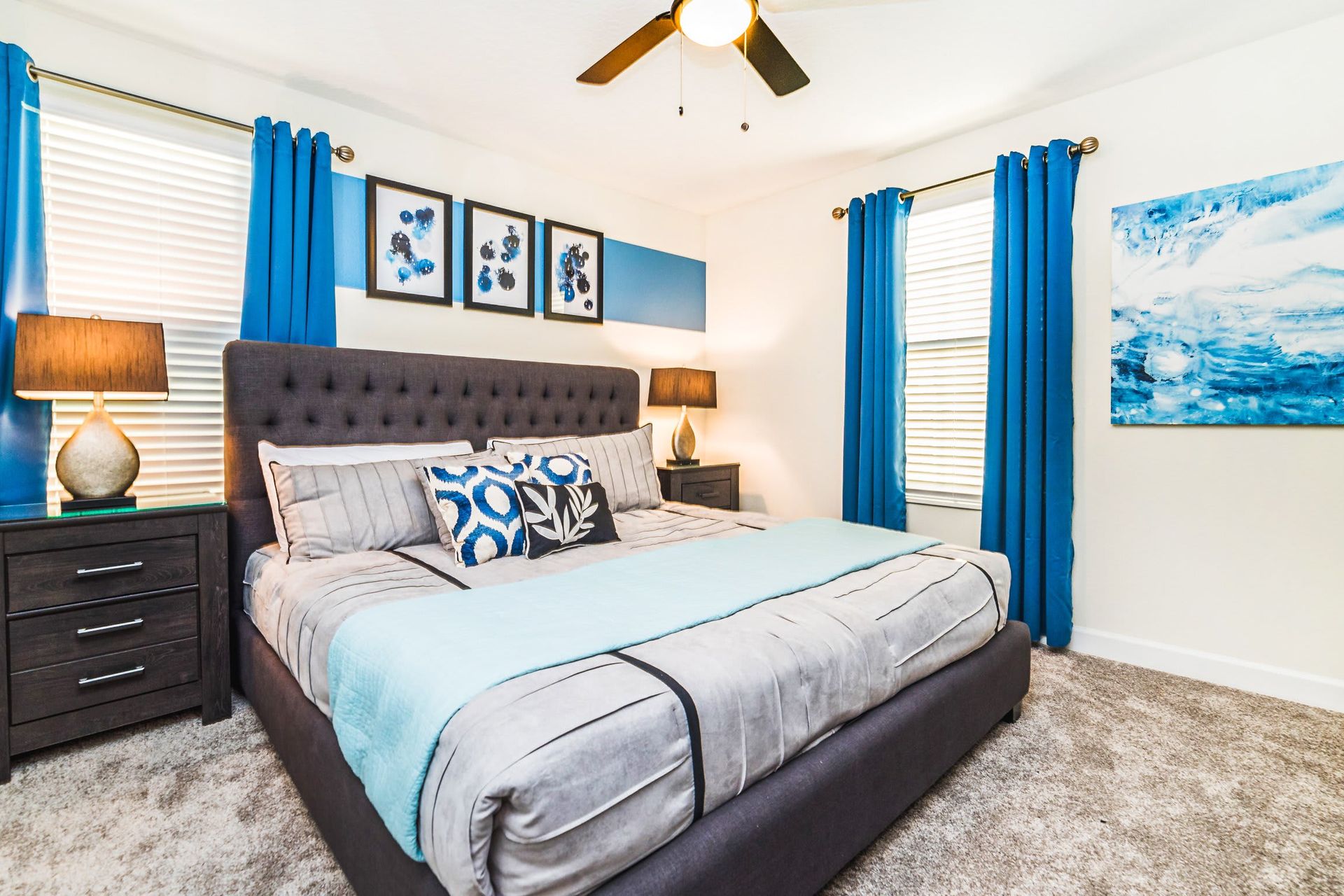 Bright bedroom with a plush king bed, bold blue accents, and modern decor.