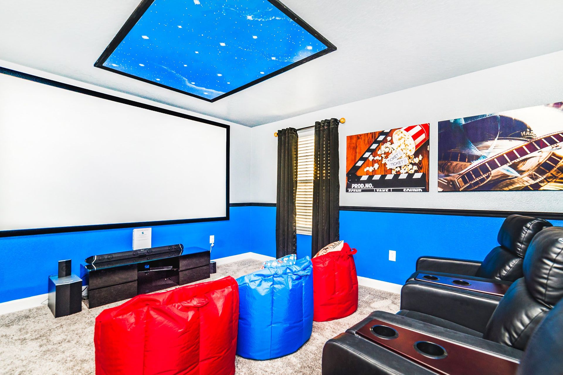 Home theater with a large screen, comfy recliners, bean bags, and starry ceiling.