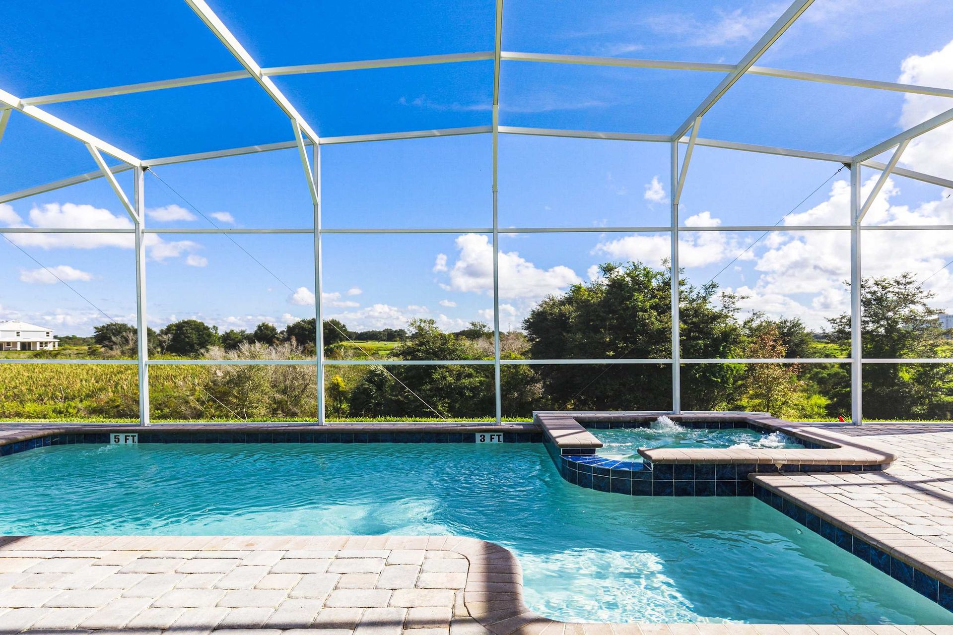 Private screened-in pool with spa, surrounded by scenic views and sunny skies.