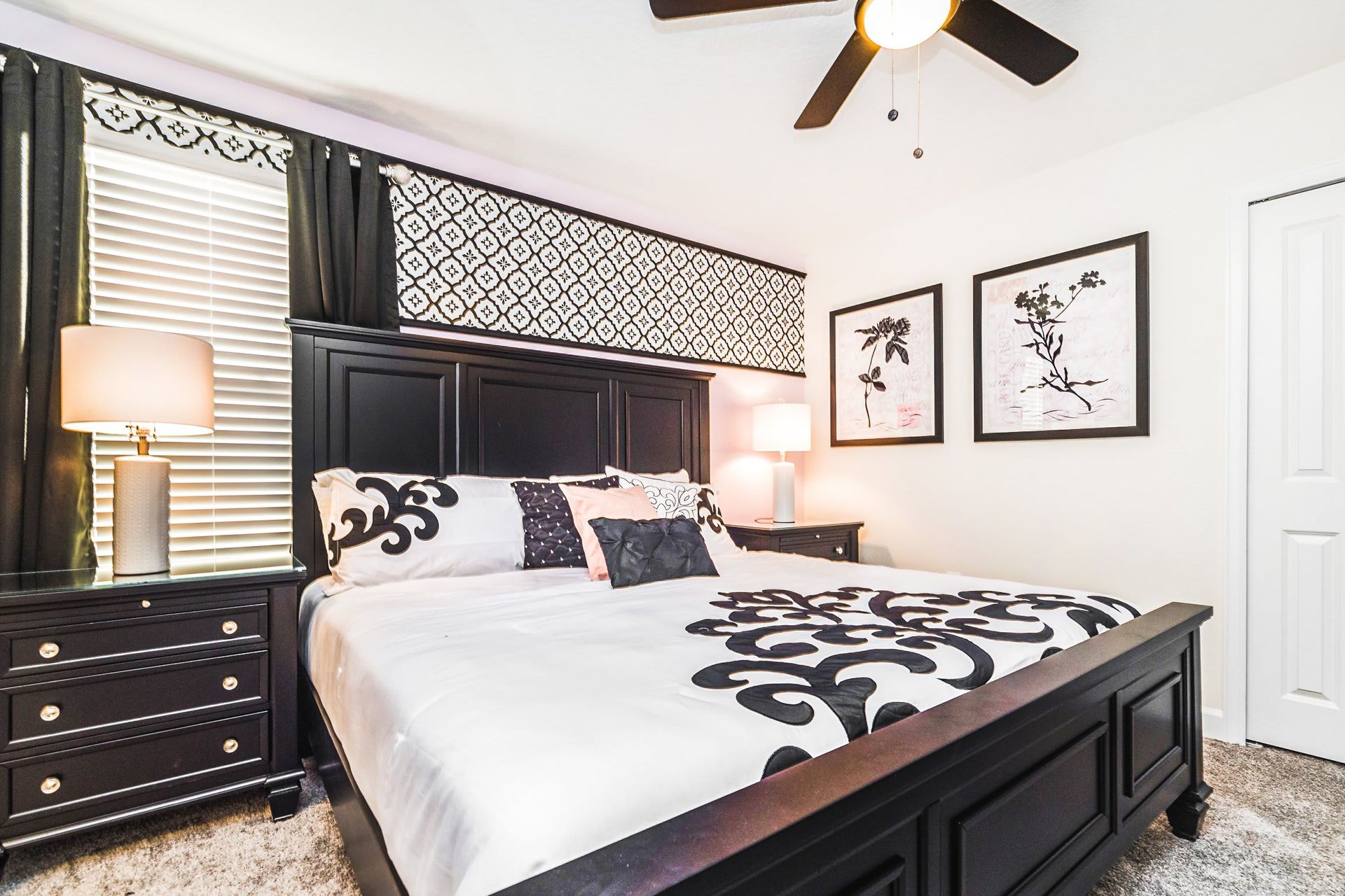 Elegant bedroom with a king bed, stylish black furniture, and chic patterned decor.
