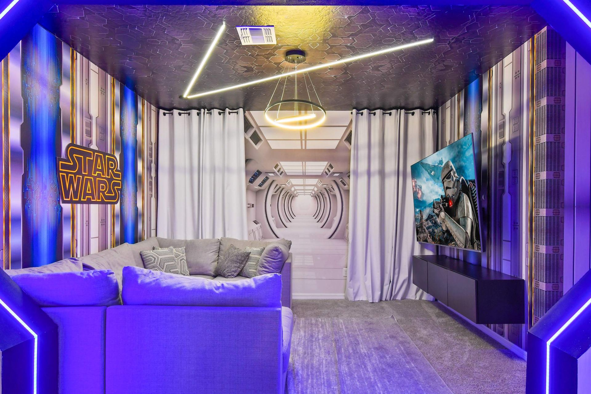 Futuristic-themed media room with cozy seating, immersive decor, and vibrant lighting.