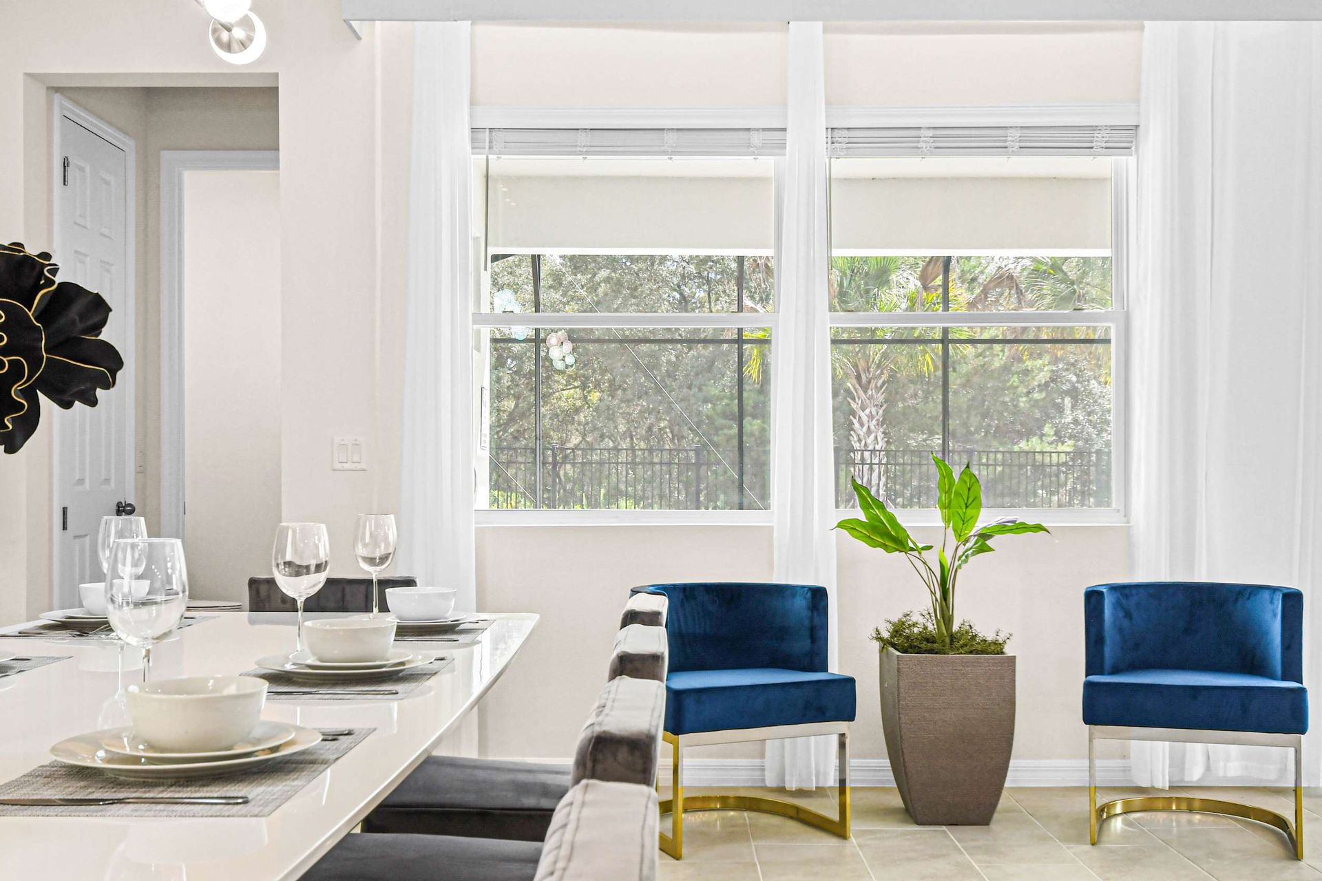 Cozy dining area with elegant table settings, vibrant blue chairs, and garden views.