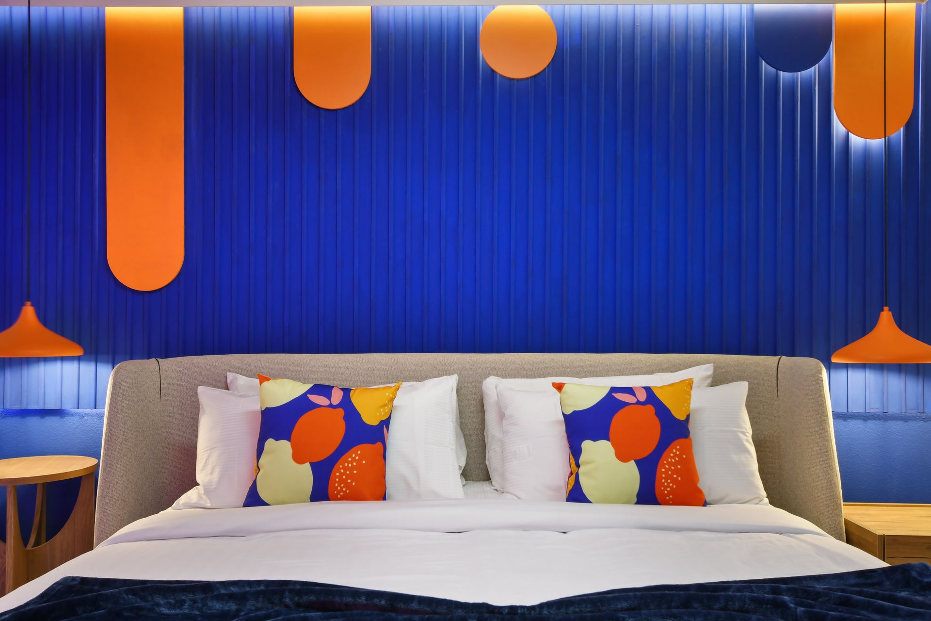 Vibrant blue and orange bedroom with bold patterns and modern accents.