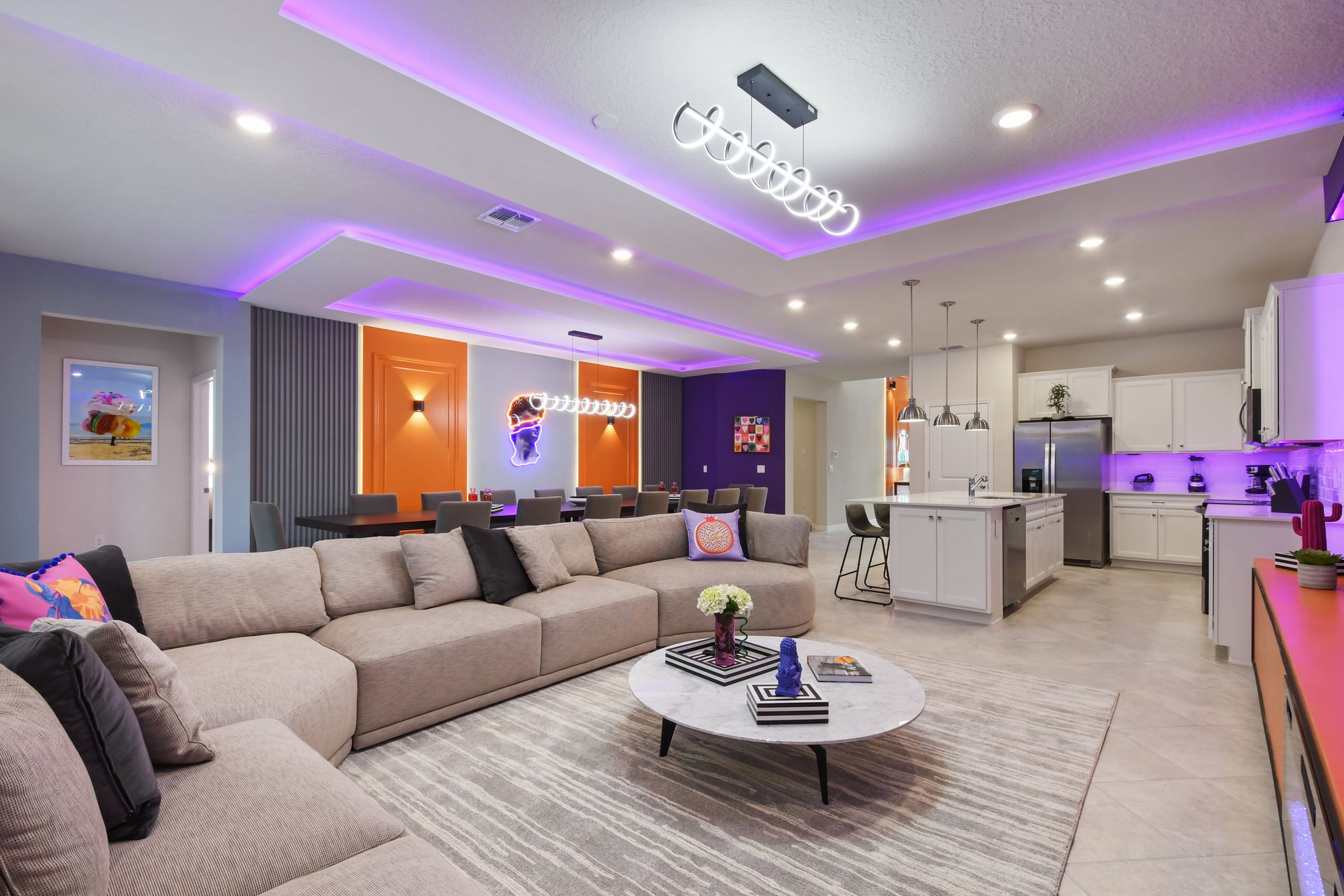Spacious open-concept living, dining, and kitchen area with vibrant neon accents.