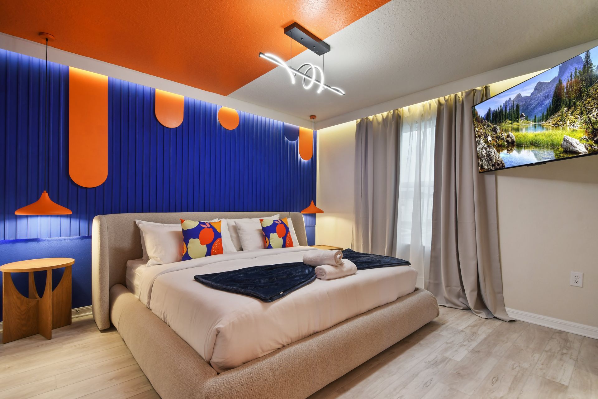 Bold modern bedroom with vibrant orange and blue accents, sleek decor.