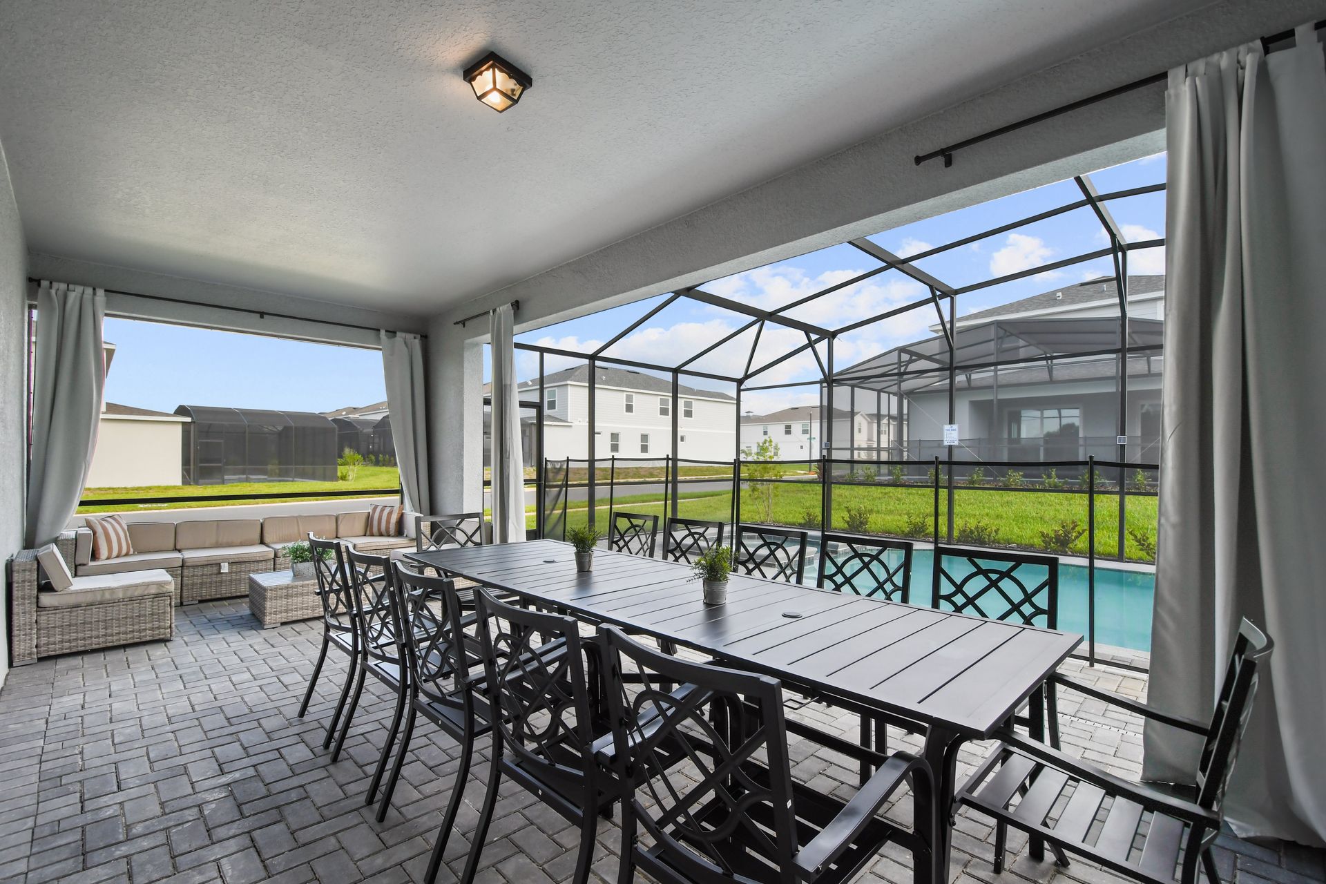 Enjoy al fresco dining by the pool in this cozy screened-in patio space.