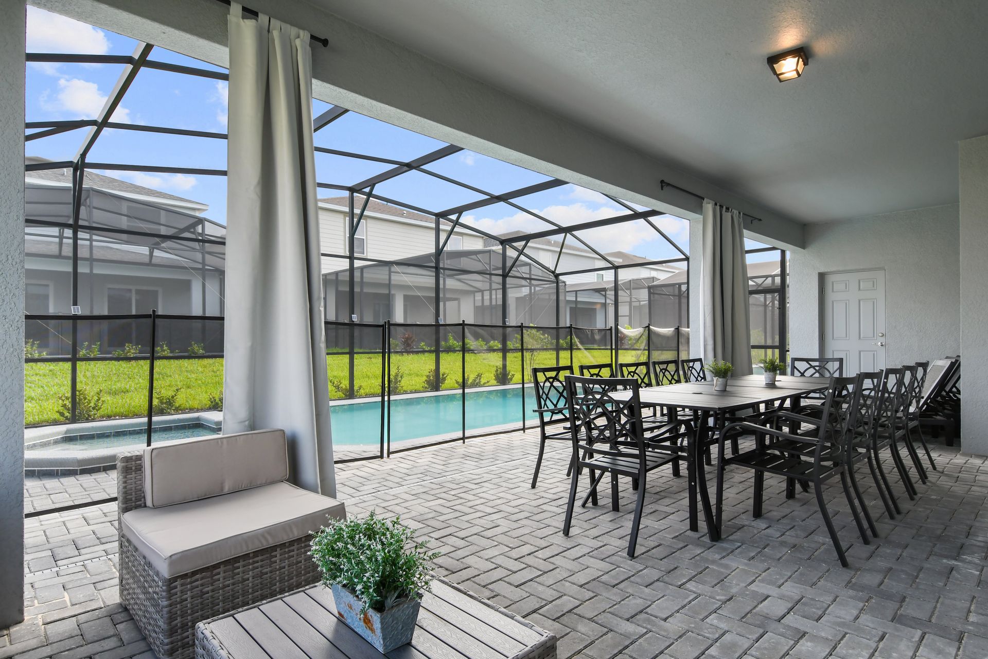 Spacious screened-in patio with dining area, perfect for poolside relaxation.