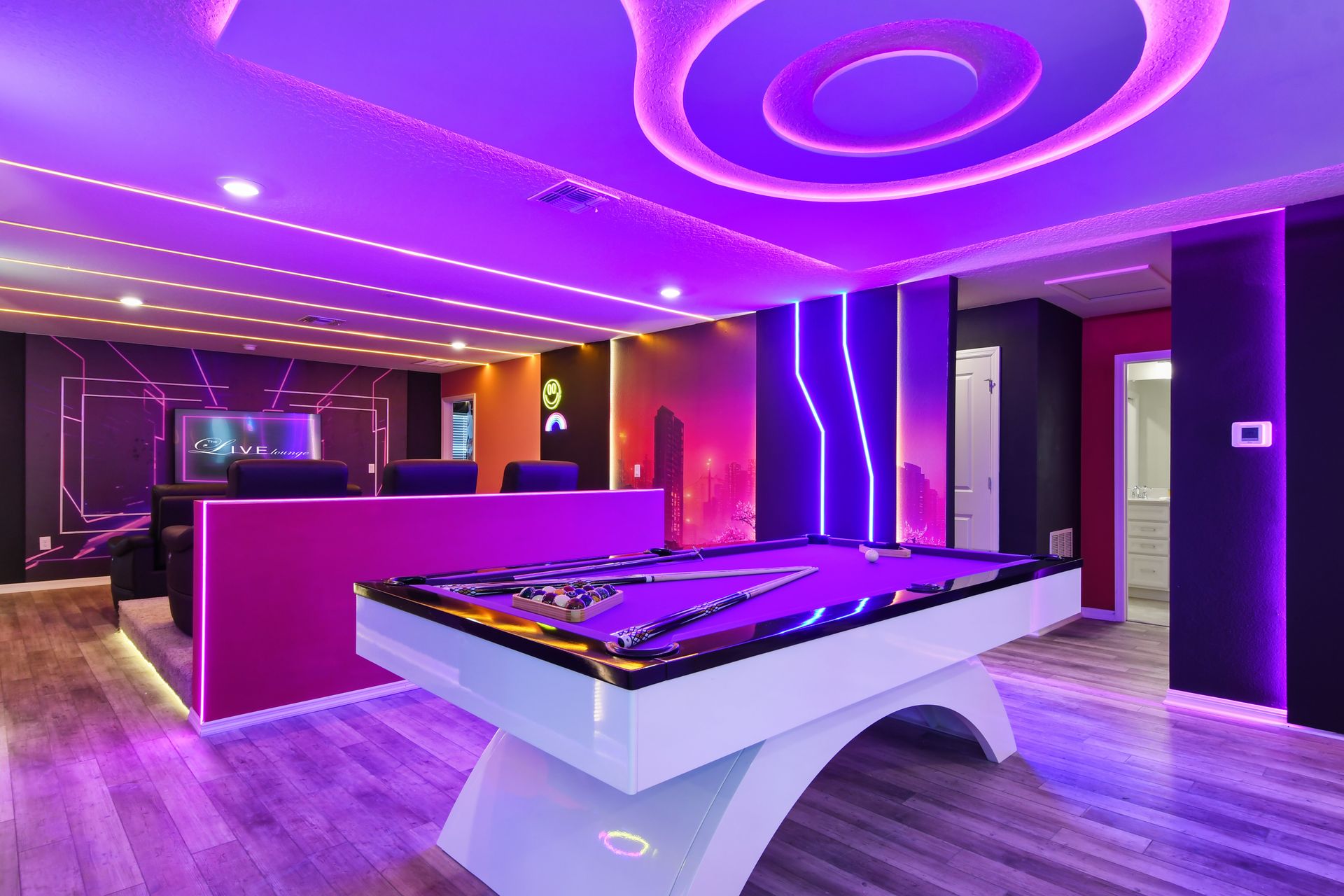 Futuristic lounge with neon-lit pool table, modern seating, and immersive vibes.