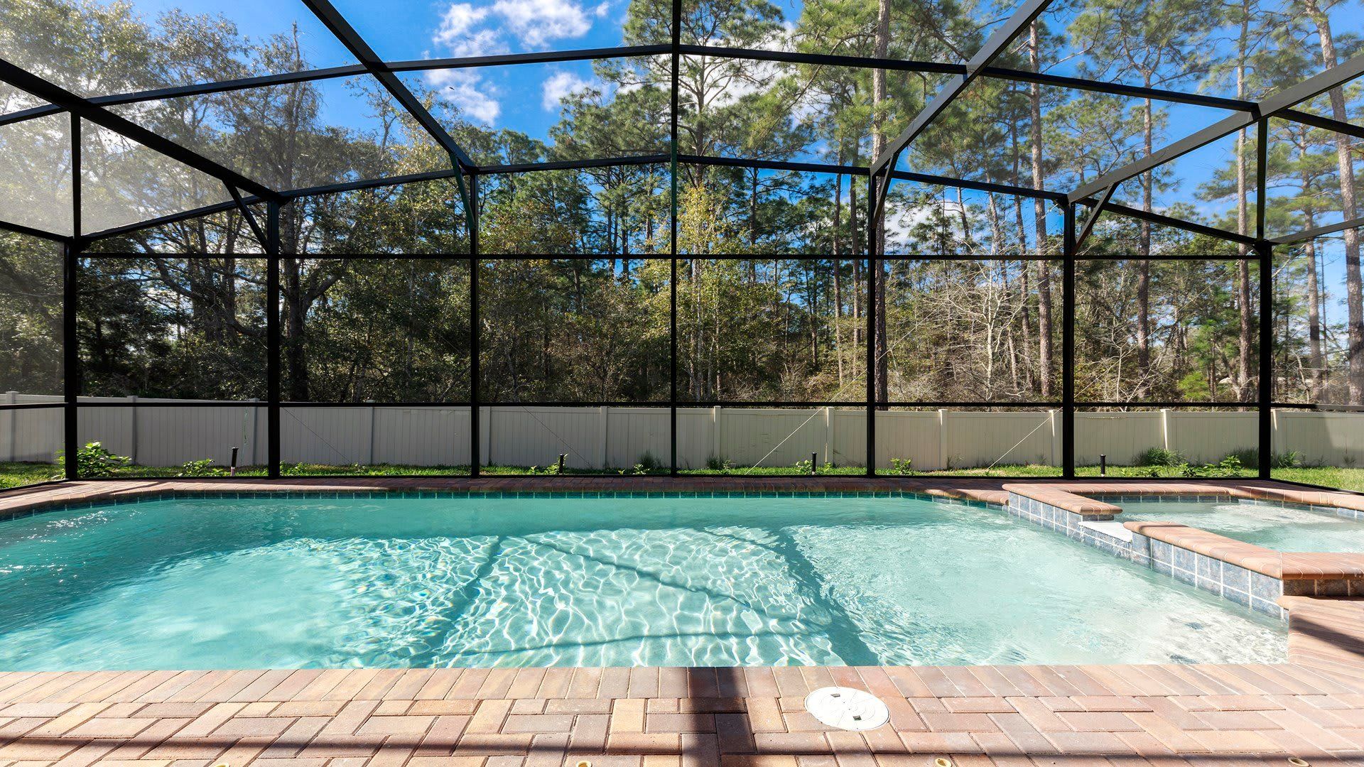Private screened pool and spa with peaceful forest views, perfect for relaxing and unwinding.