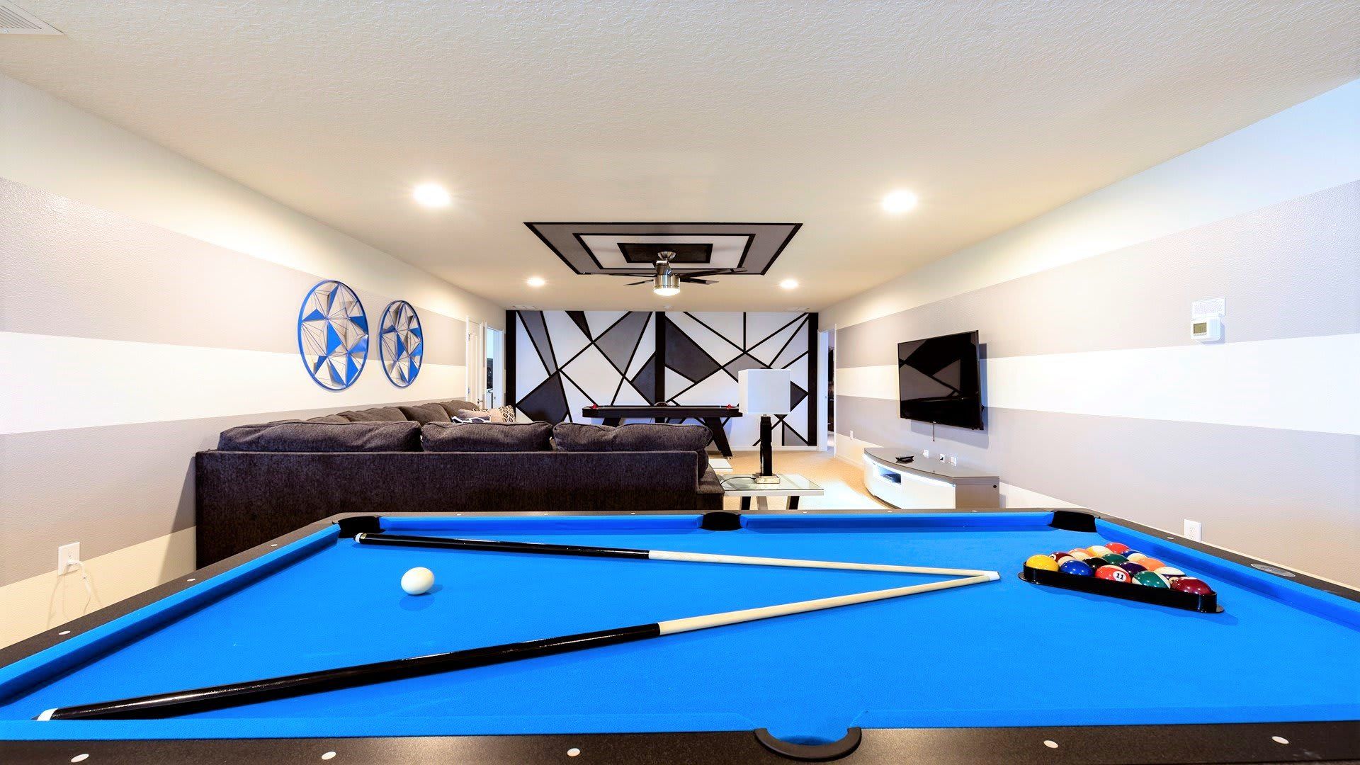 Ultimate game room with pool table, themed decor, and comfy seating.