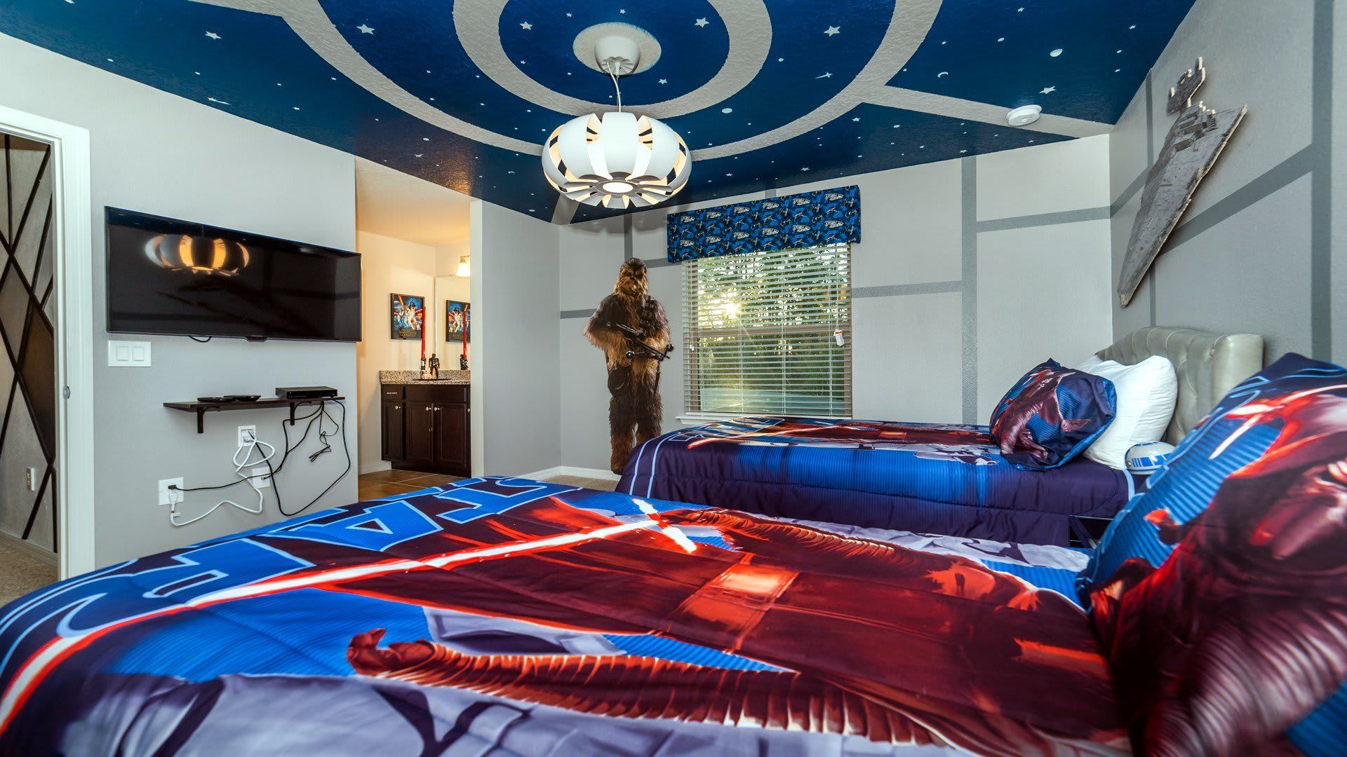 Star Wars-themed bedroom with spaceship ceiling, character cutouts, and twin beds for a fun adventure.