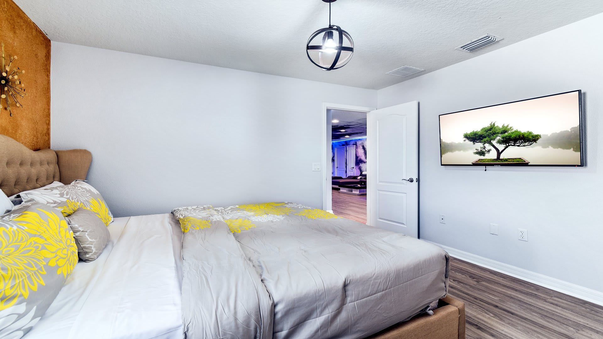 Bright and cozy bedroom with stylish decor and a calming tree view on the mounted TV.