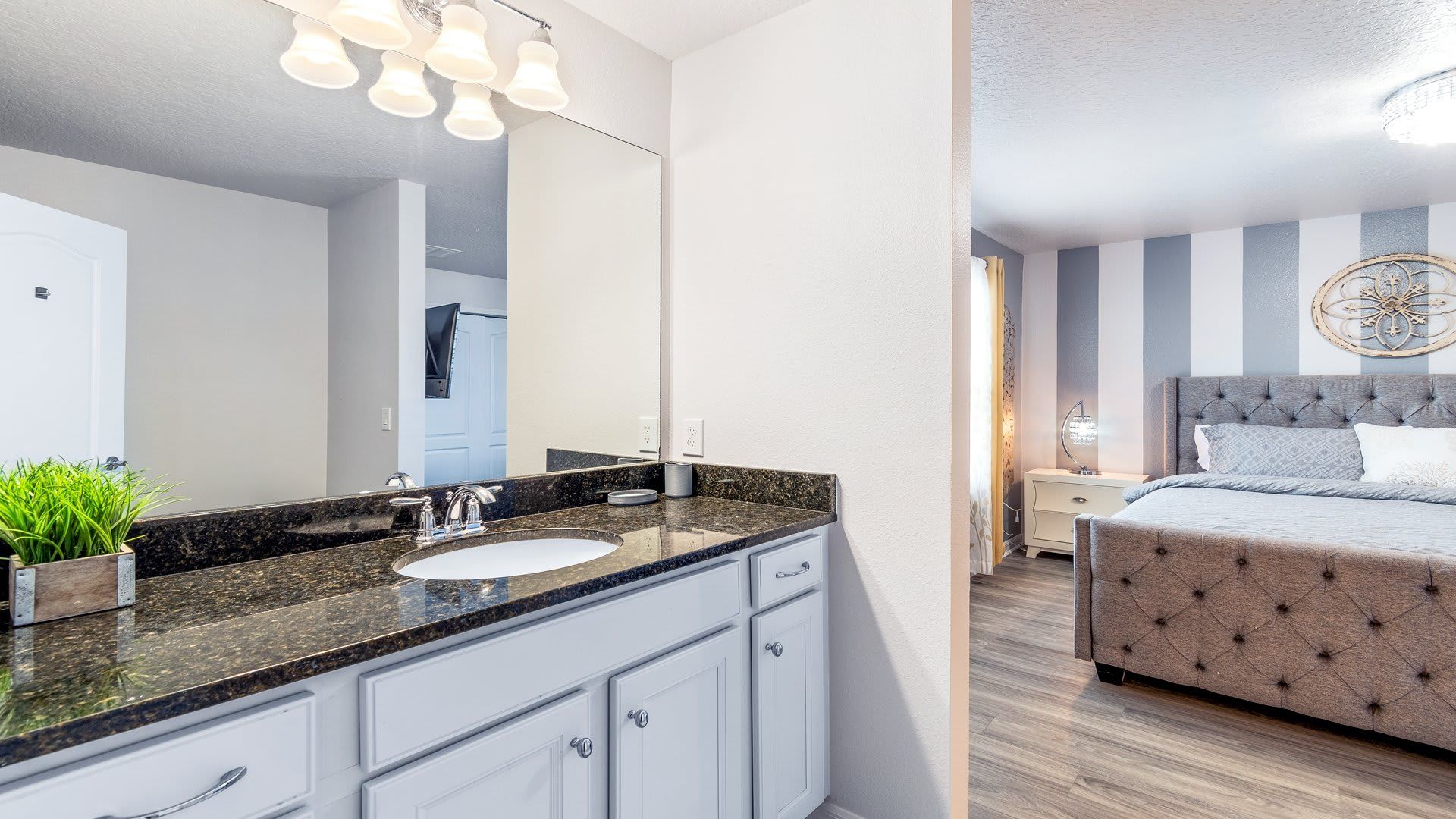 Modern bathroom with dual granite sinks, vibrant decor, and a sleek glass-enclosed shower!