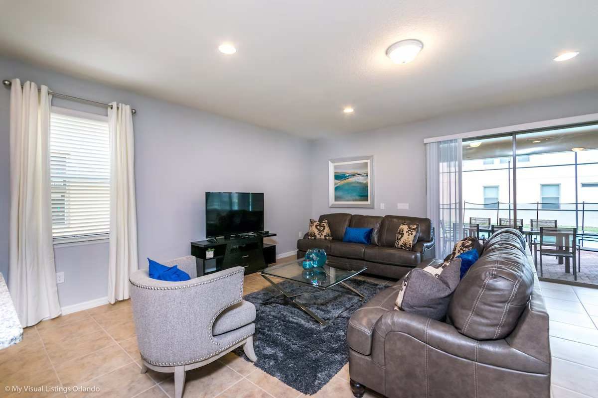 Modern & cozy living space with plush seating, TV, and patio access—relax here!
