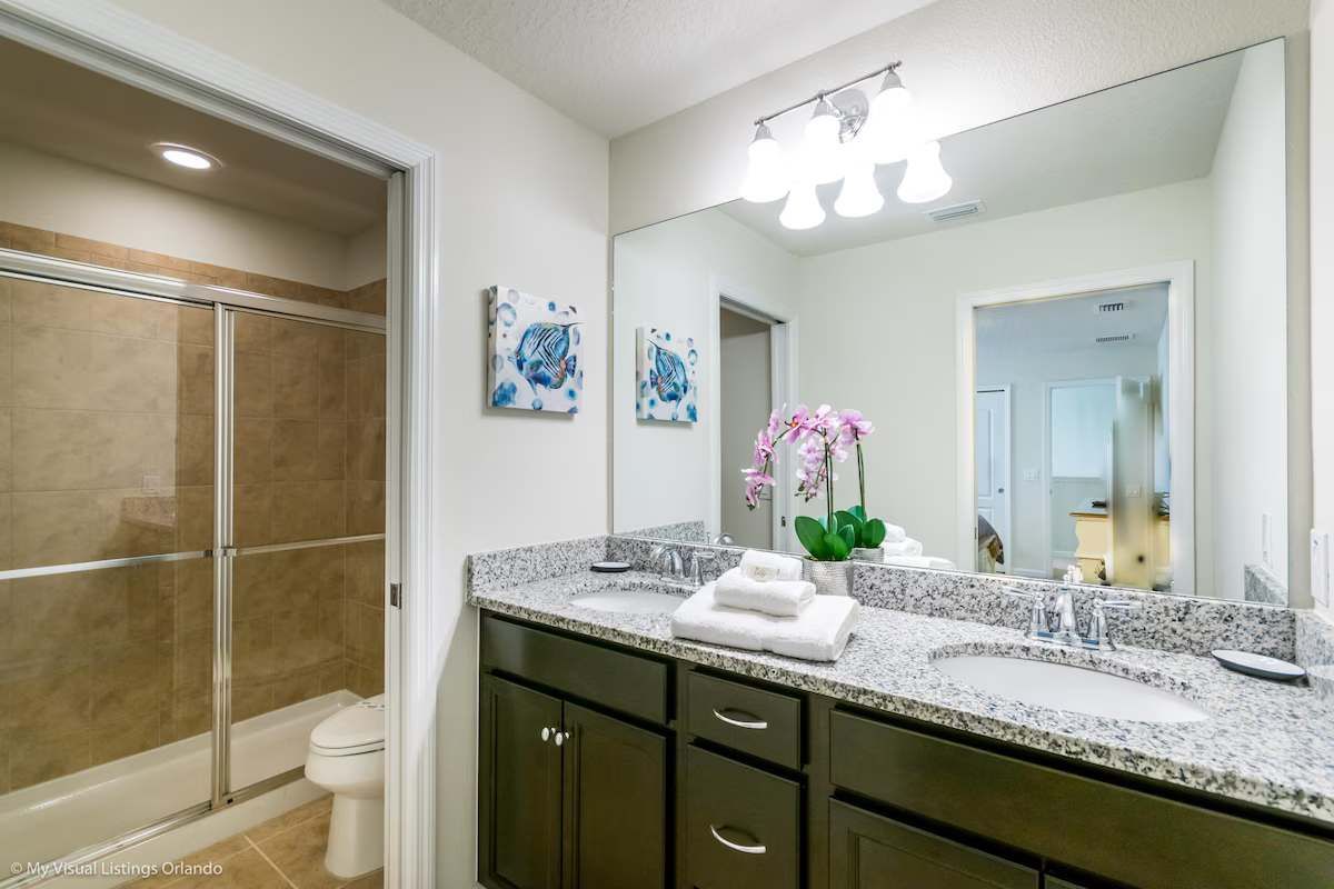 Elegant bathroom with dual sinks, granite countertops & a sleek glass-enclosed shower!