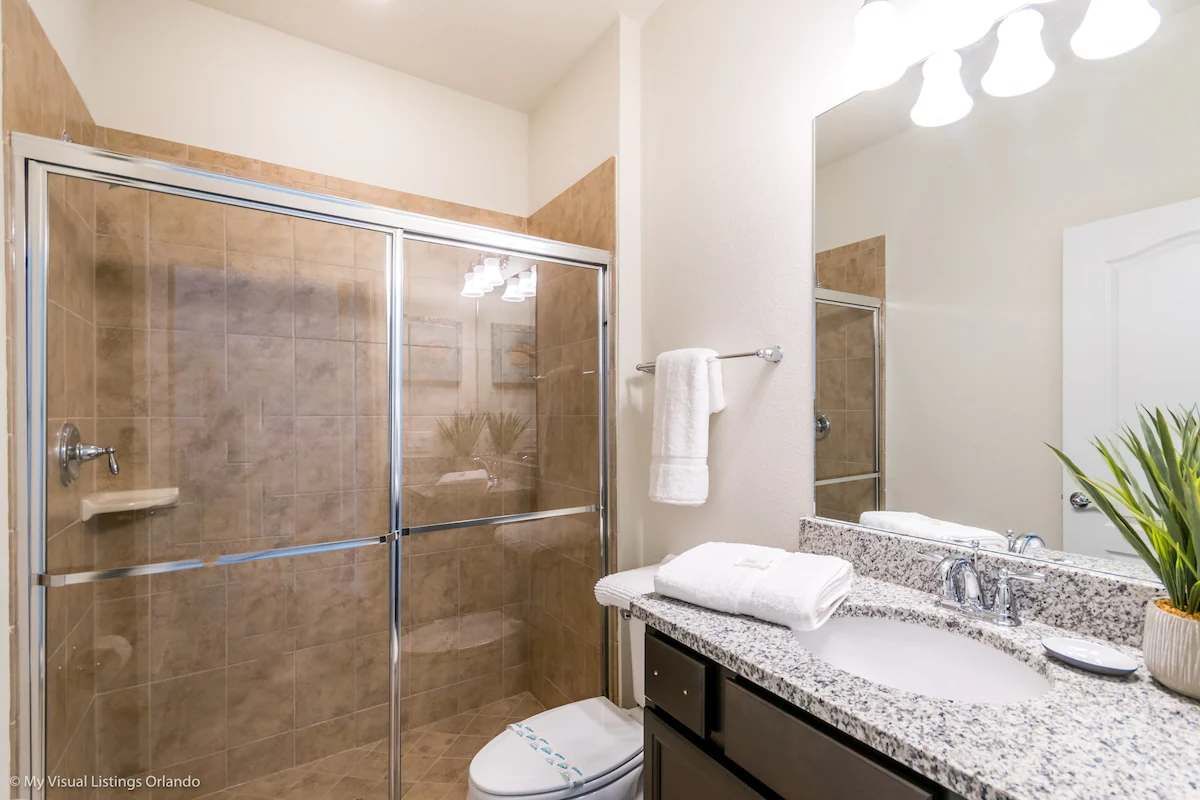 Stylish bathroom with granite vanity, glass-enclosed shower & modern decor!