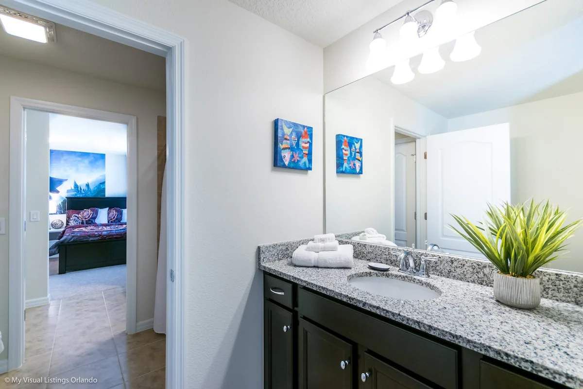 Modern bathroom with granite vanity, bright lighting & access to themed bedroom!