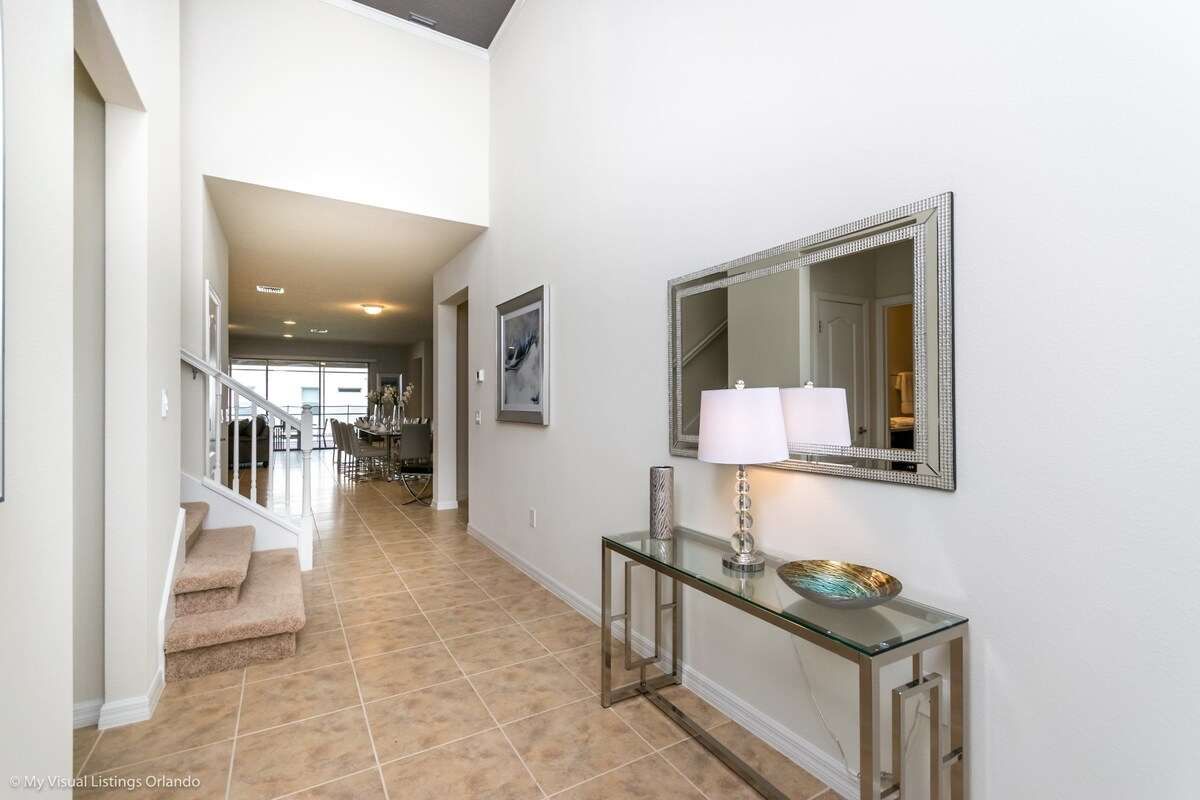 Elegant entryway with modern decor, high ceilings & a warm, welcoming ambiance!