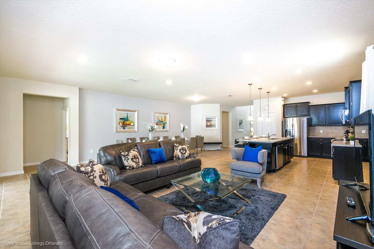 Spacious open-concept living area with stylish decor, plush seating & modern kitchen!