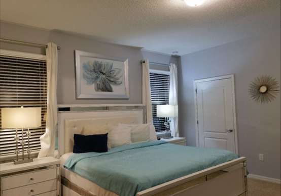 Elegant bedroom with a plush king bed, stylish decor & warm ambient lighting!