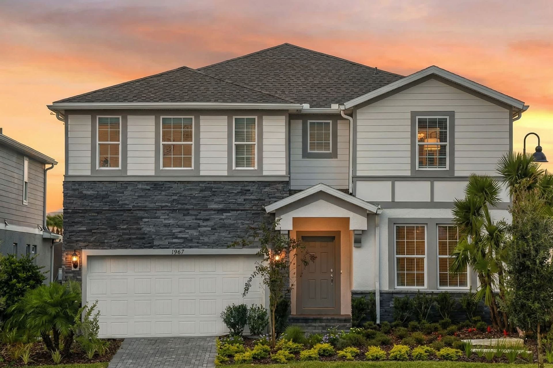 Stunning modern home with elegant design, lush landscaping, and a warm sunset glow!