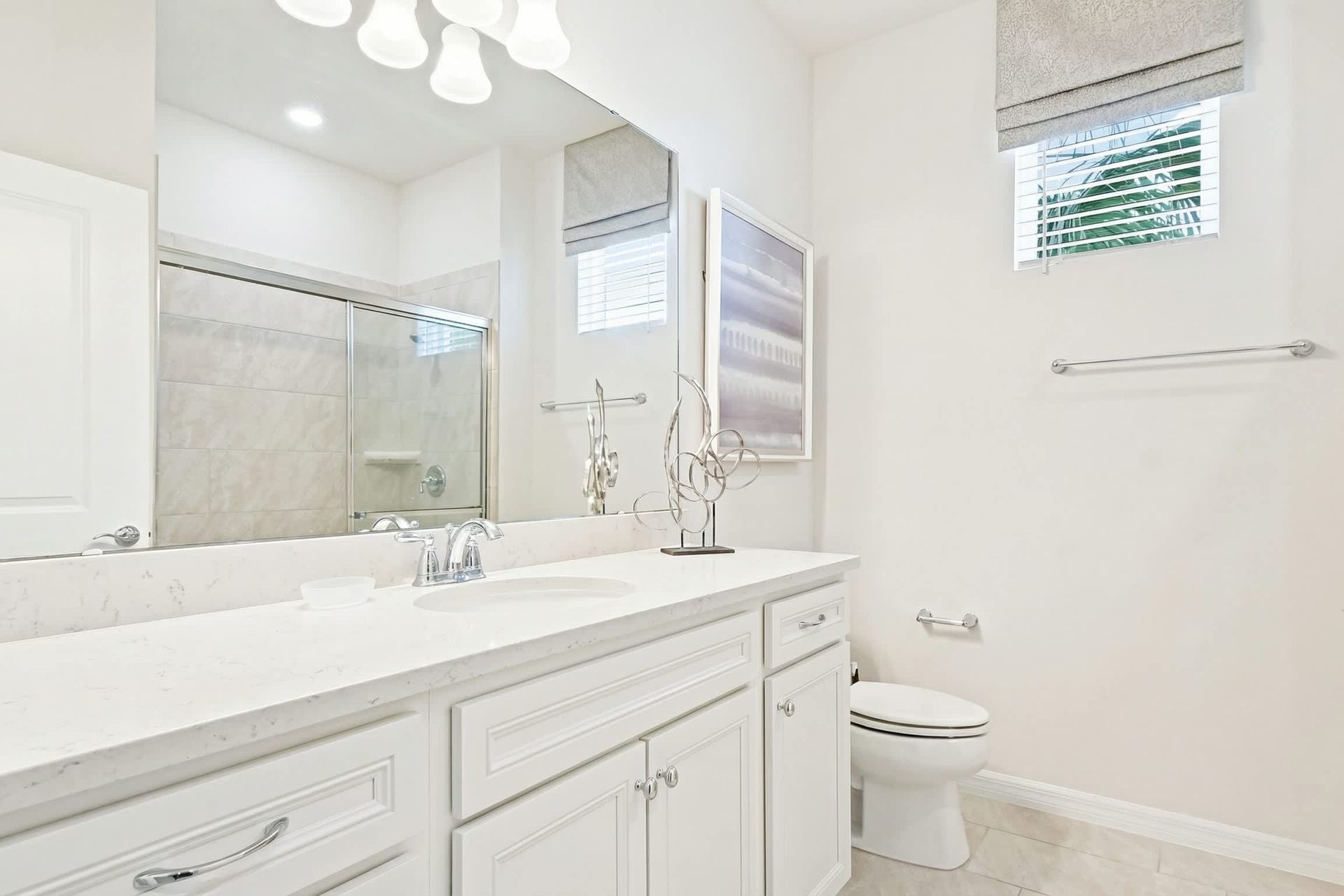 Elegant bathroom with a sleek vanity, glass shower, and bright, modern decor!