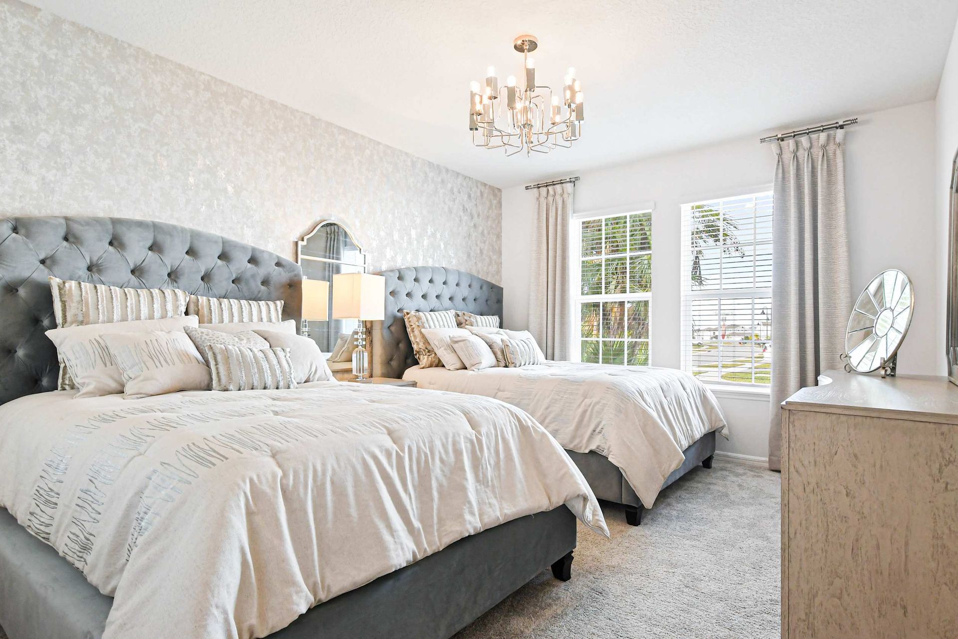 Luxurious double queen bedroom with plush bedding, chic decor, and natural light!