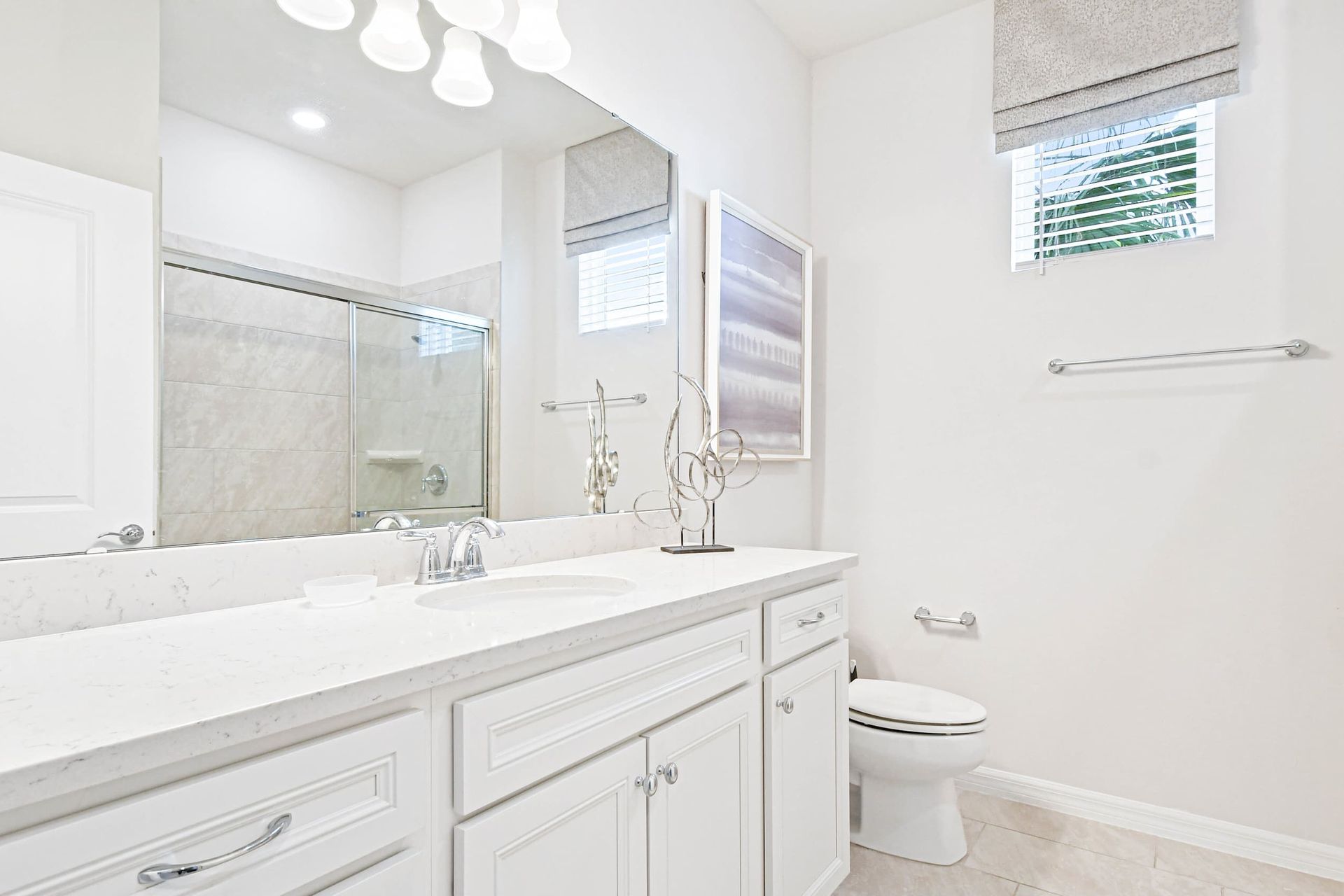 Elegant bathroom with a sleek vanity, glass shower, and bright, modern decor!